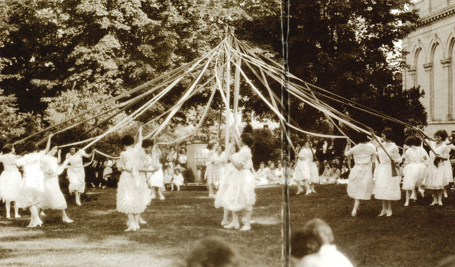 sepia photos of women in white dresses dancing around a may pole with streamers by Penn State Archives