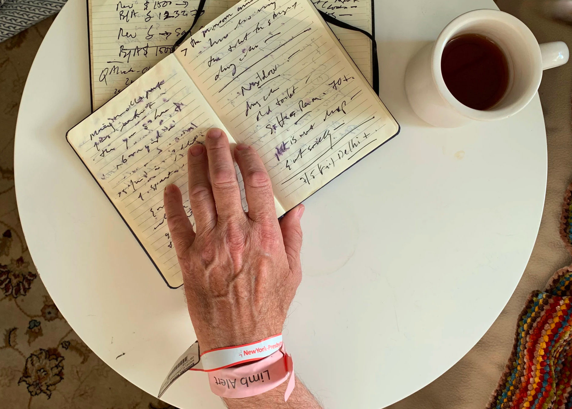 Nordland's hand on one of his journals and hospital bracelet around his wrist, courtesy