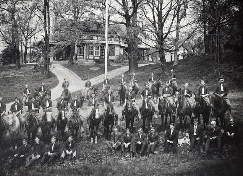 Black and white image of students and horses on a lawn