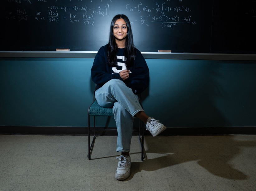 photo of Divya Tyago seated in front of a chalkboard by Cardoni