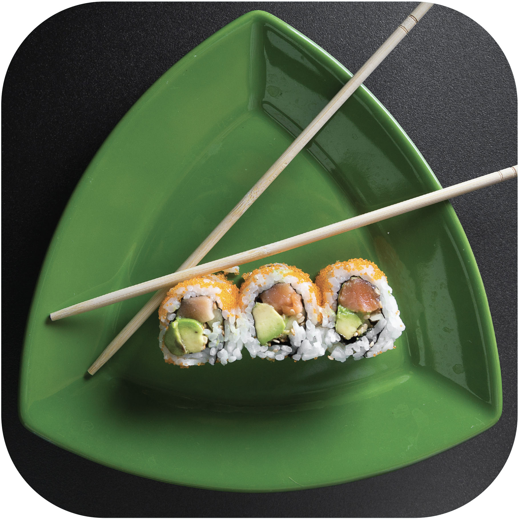 three bites of sushi and chopsticks on a green triangular plate