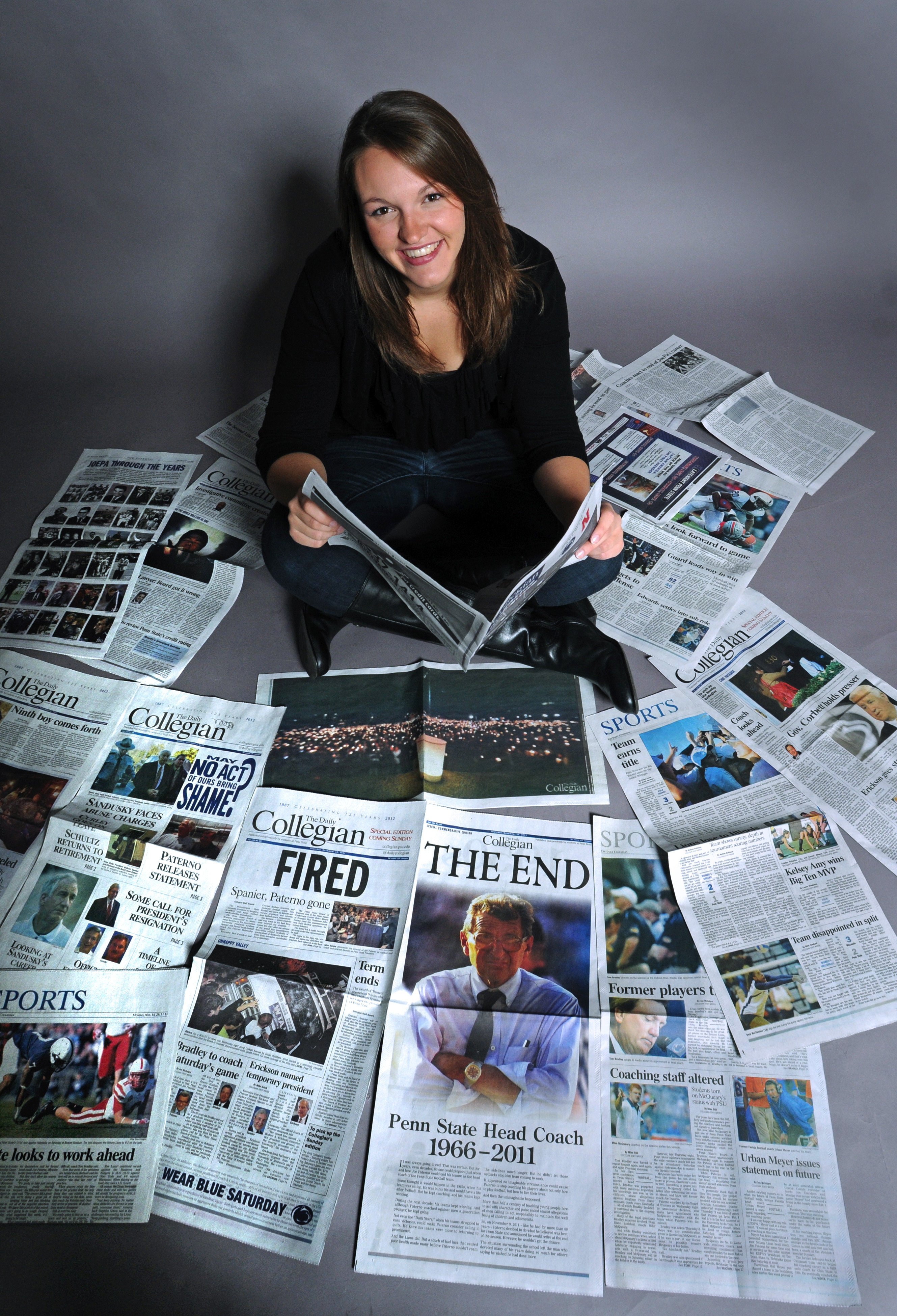 photo of Brittany Horn sitting on the floor amid dozens of copies of the Daily Collegian, by Jeff Ruppenthal/Lancaster Newspapers