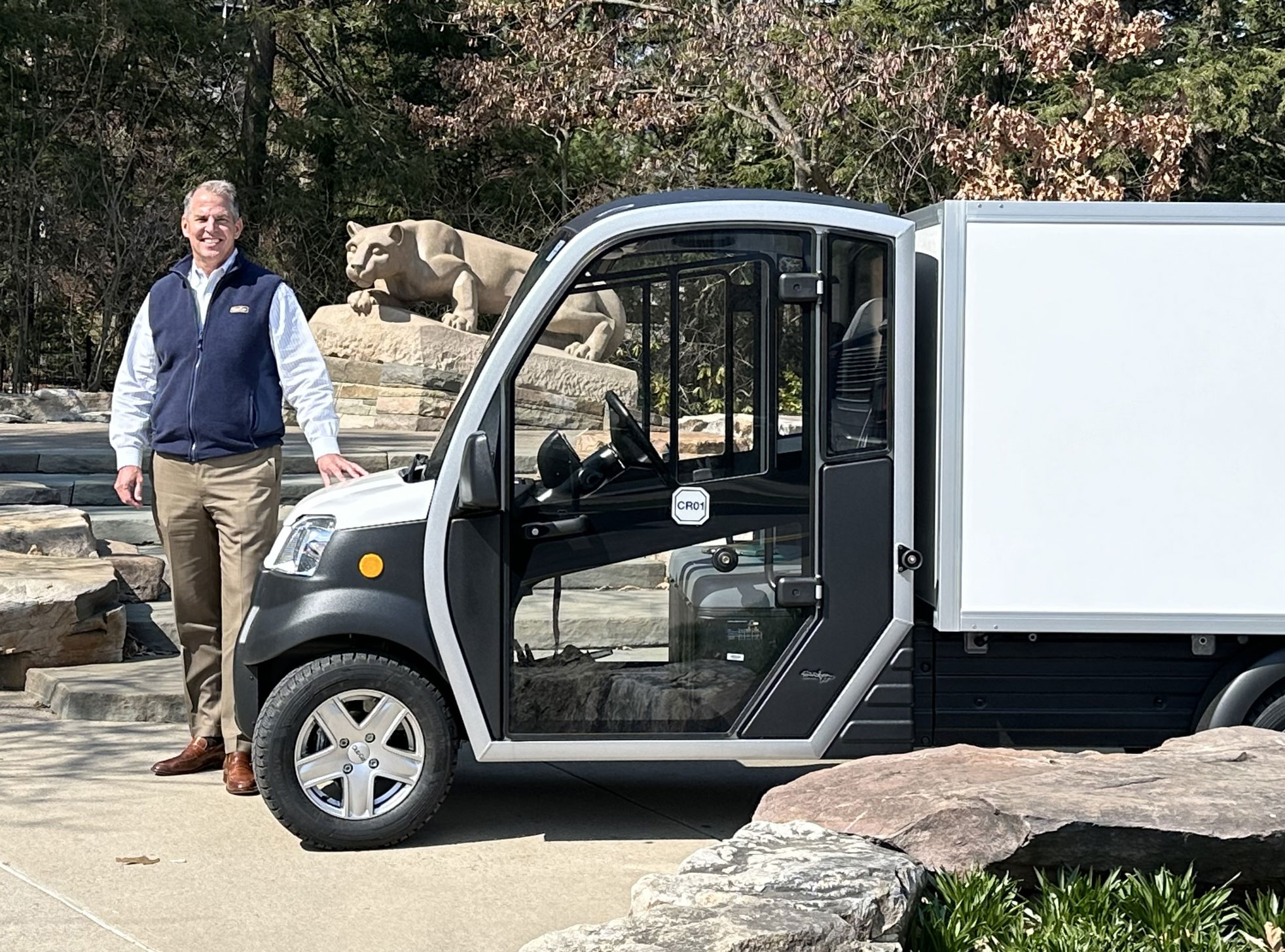 Mark Wagner standing next to an electric vehicle, courtesy