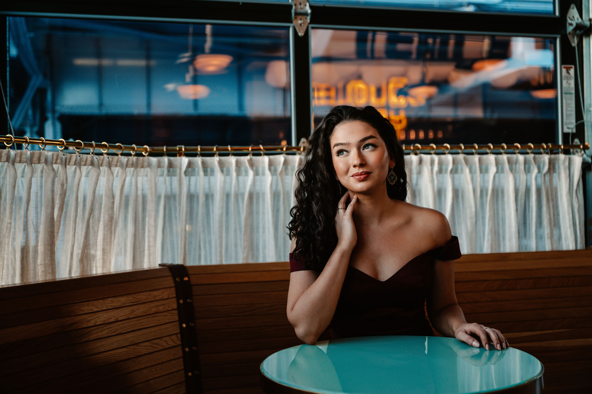 Lisa Rogali seated at a round green table in a cafe, photo by Jiyang Chen