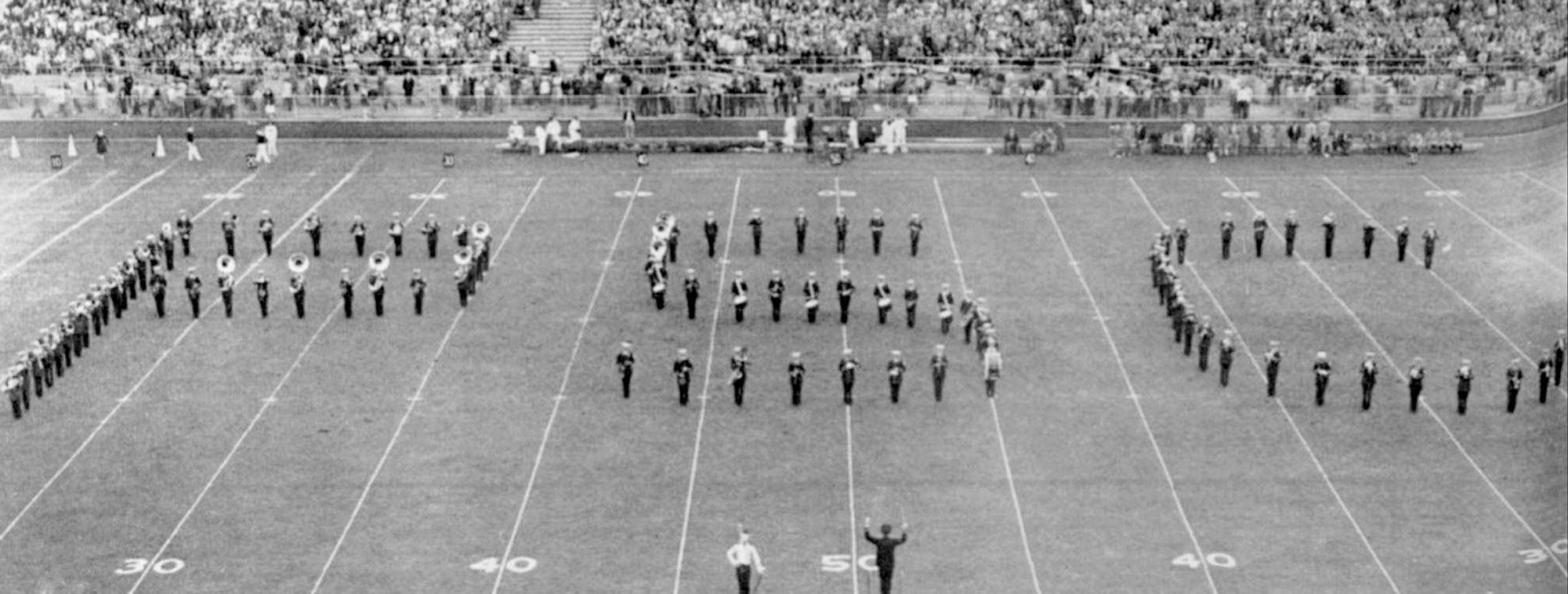 black and white photo of the Blue Band spelling PSC on the field, by Penn State Archives