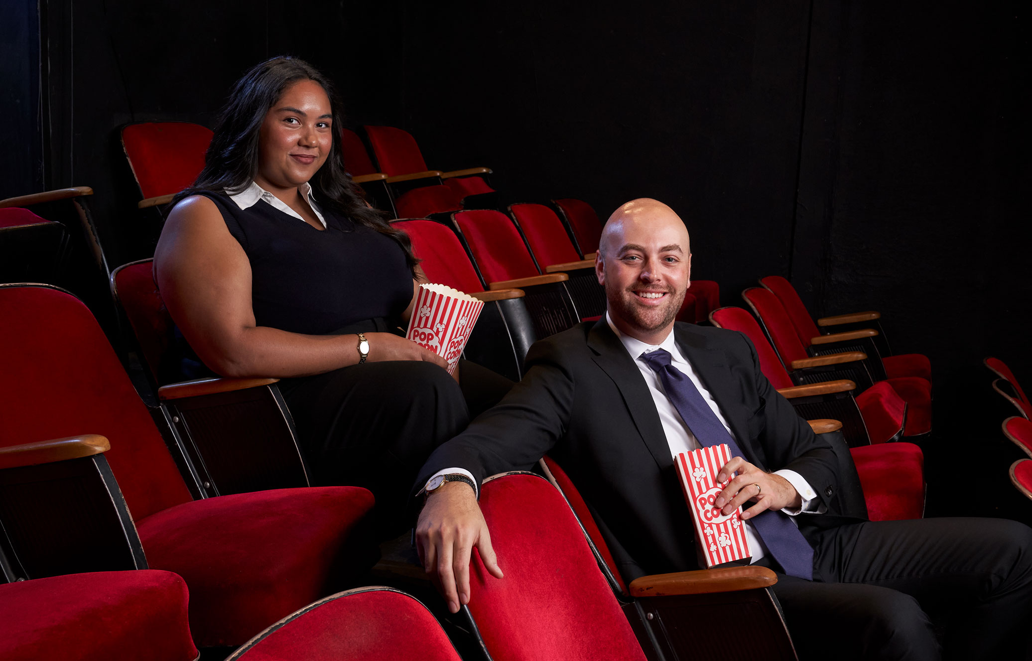 photo of two Hollywood Program alums seated in a theater of red seats by Gregg Sega