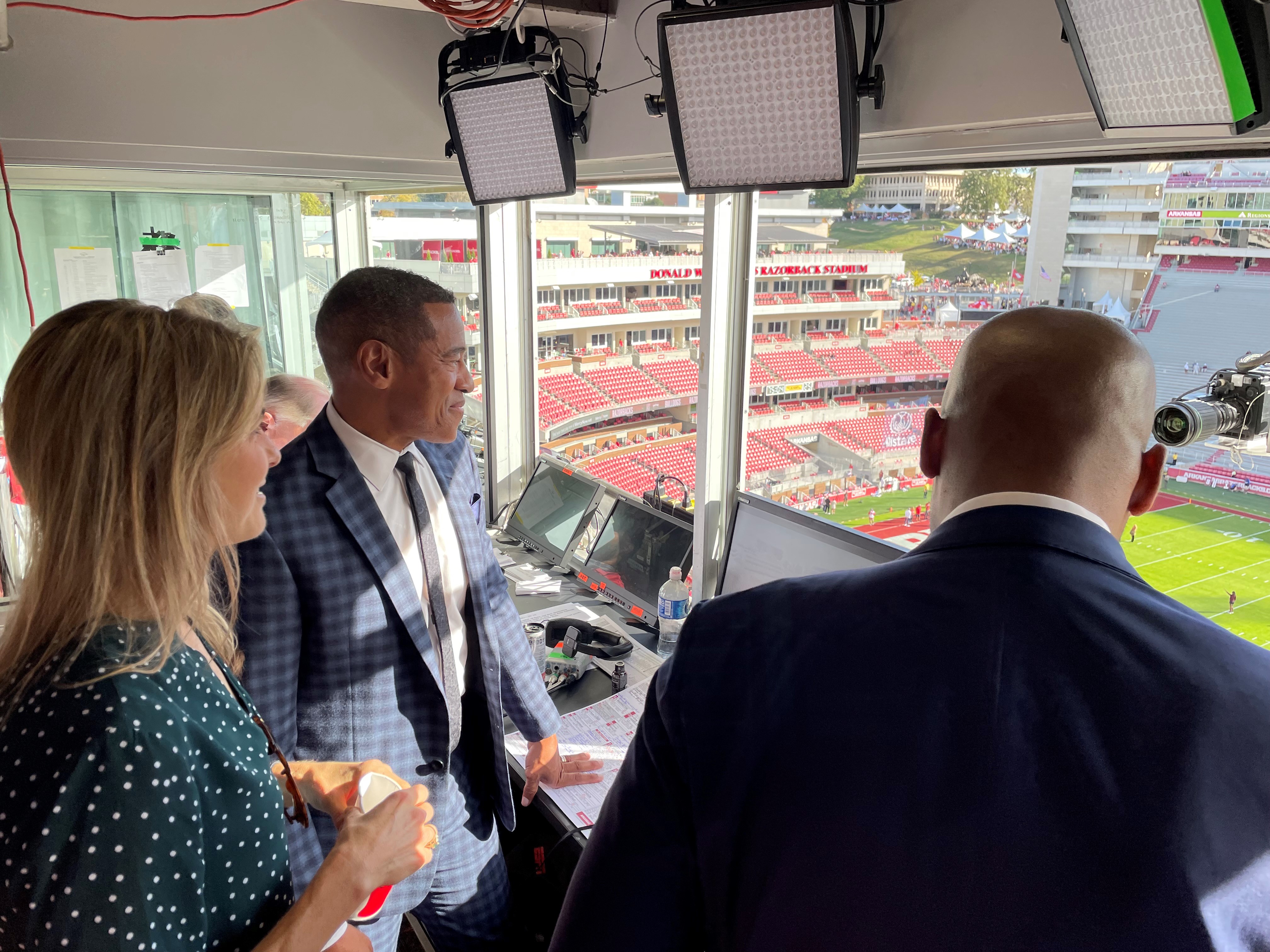 Gifford and colleague in press box overlooking football field, courtesy