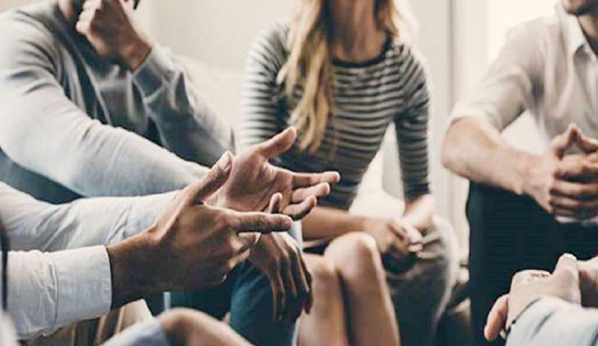 photo of a group of people in a circle with focus on their hands