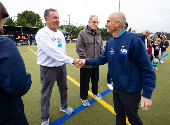 photo of two men shaking hands outside, courtesy