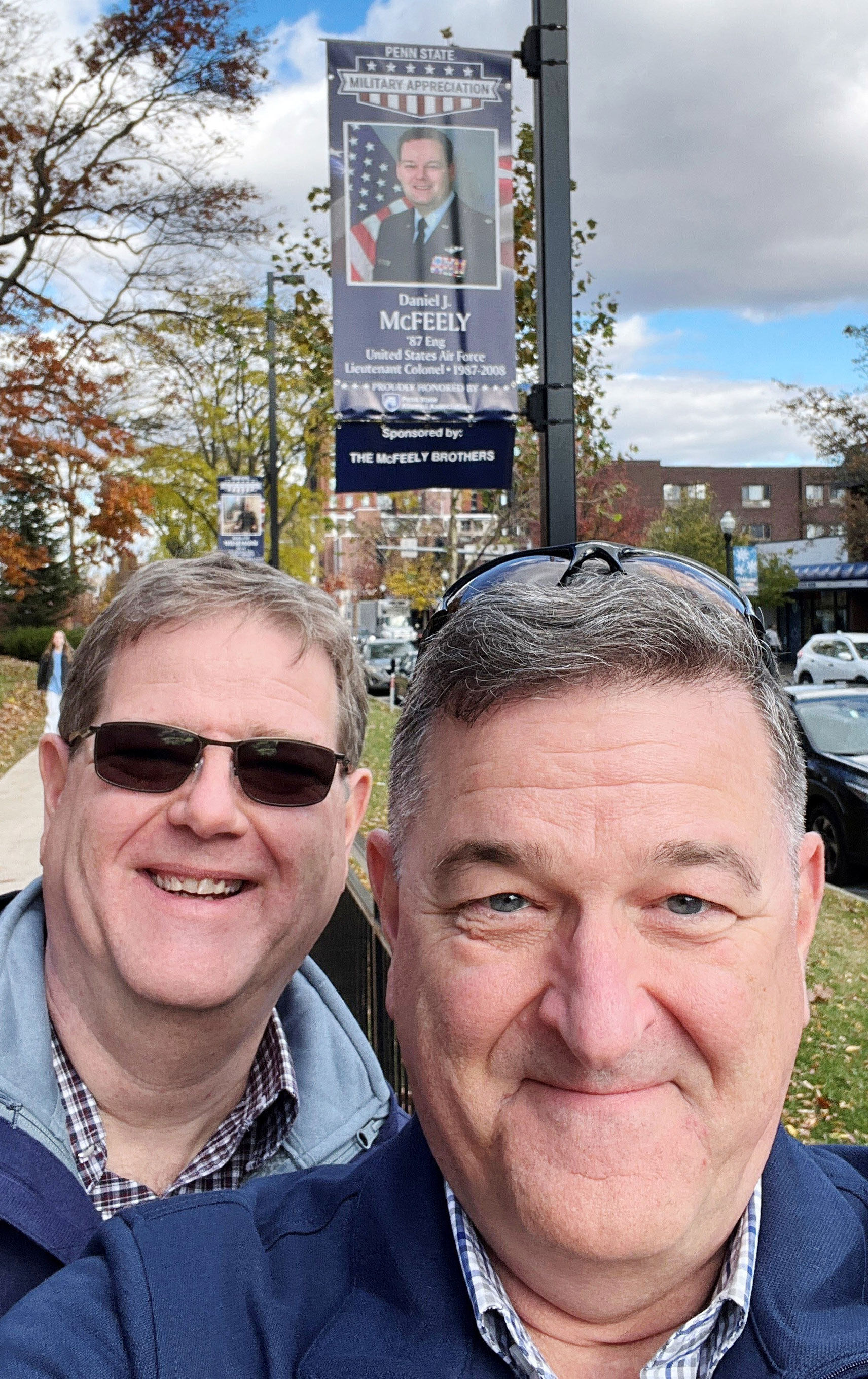 McFeely poses near military banner at University Park, courtesy