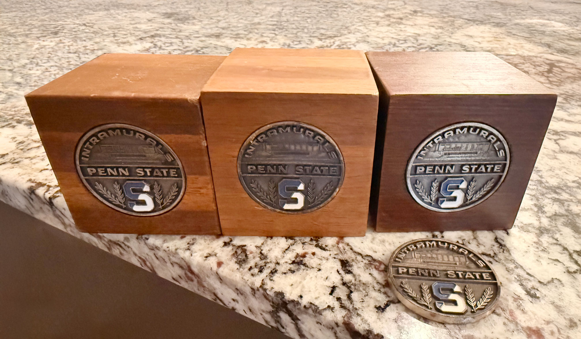 three medals in wooden boxes, courtesy Arcuri