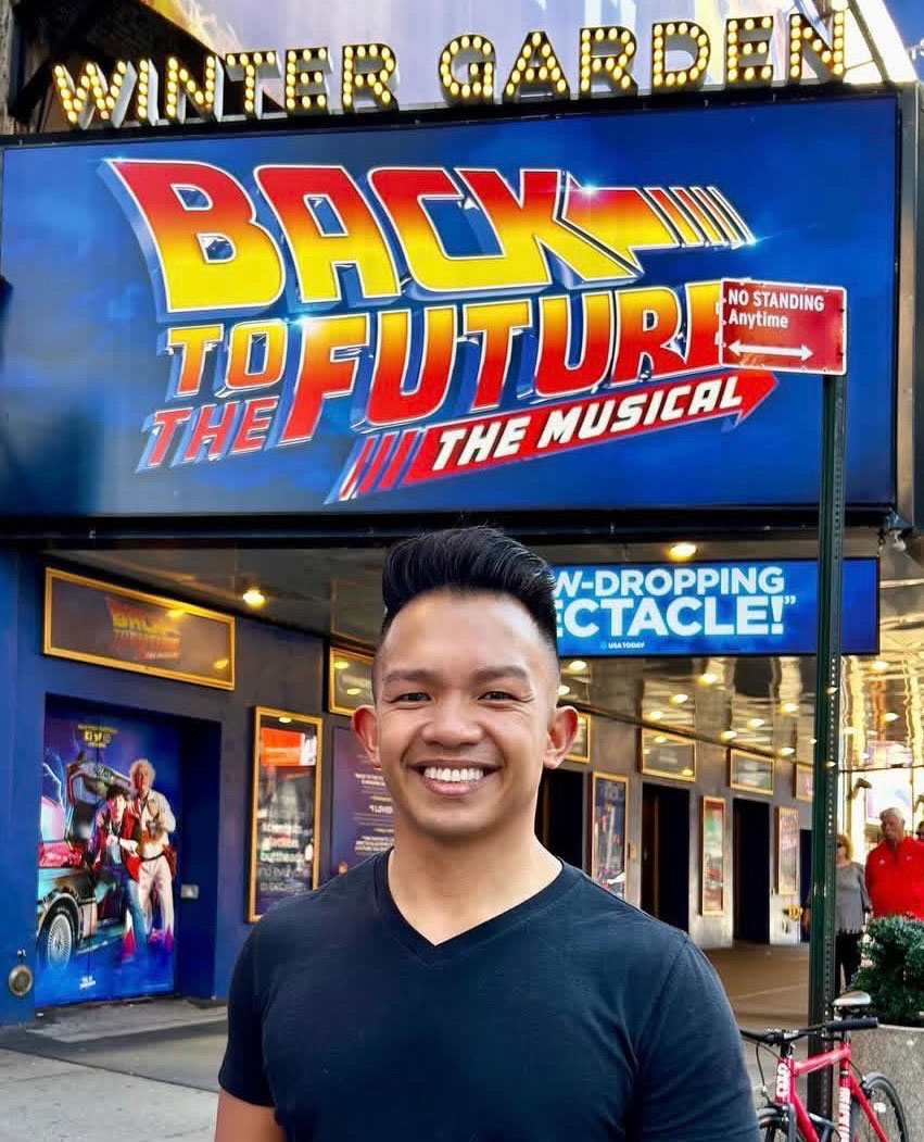 Angud head shot before Back to the Future The Musical signage, courtesy