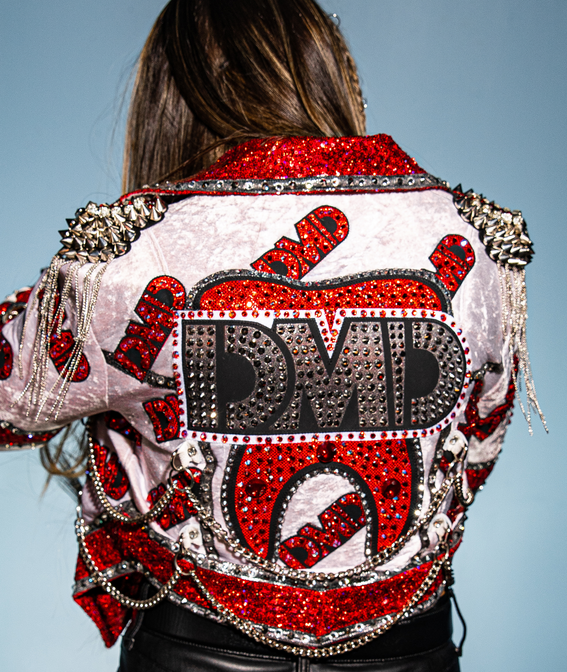 Britt Baker with her back to the camera wearing a rhinestone encrusted jacket with DMD on the back by Cardoni