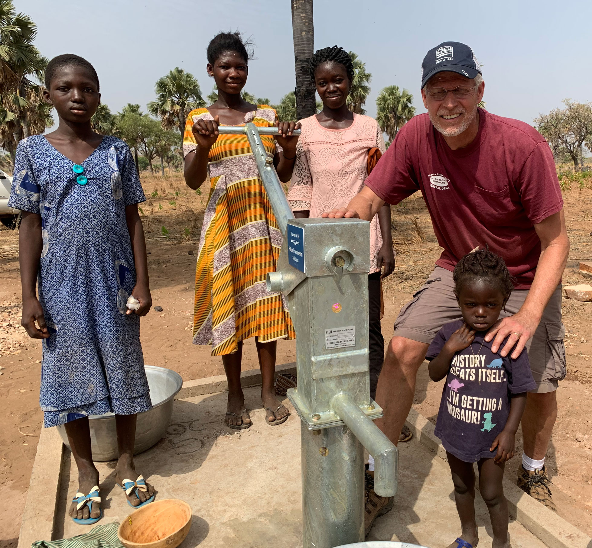 Powell with African villagers, courtesy