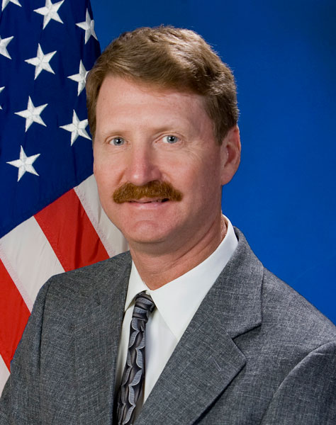head shot Elder Vogel Jr. in front of American flag, courtesy