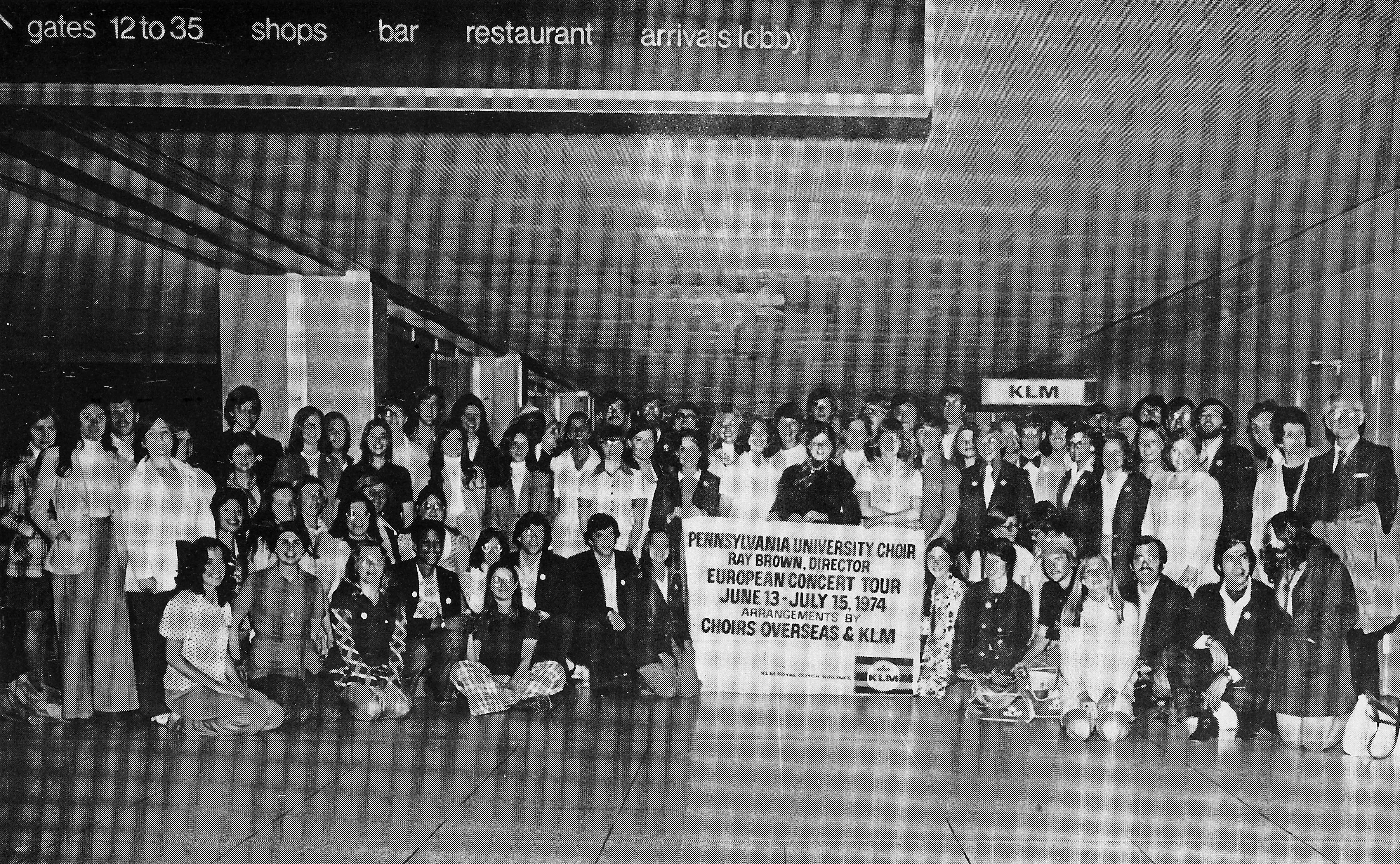 black and white photo of a large group of people at an airport, courtesy