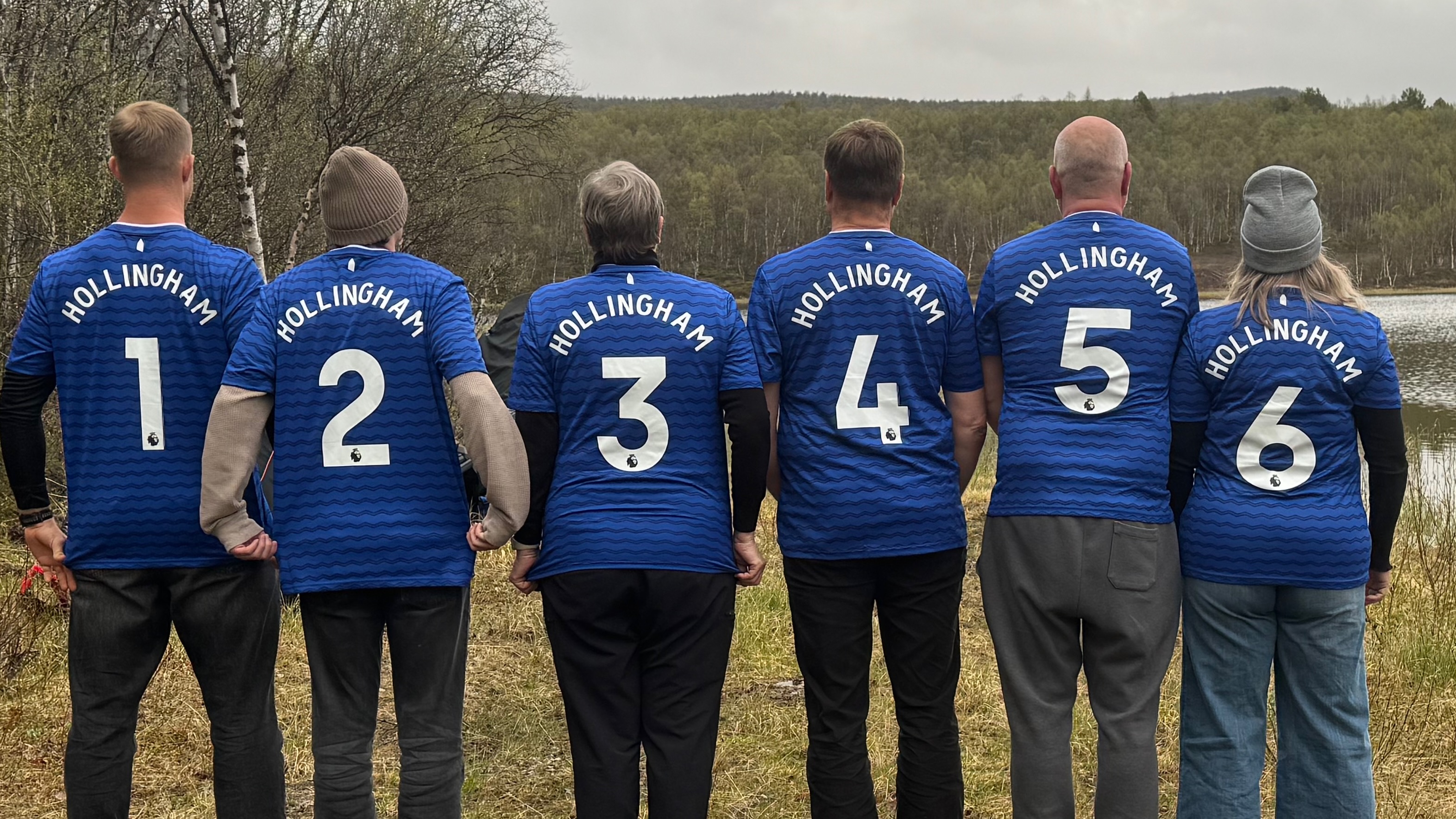 Hollingham with his and Lovisa's parents showing the back of their custom jerseys that say Hollingham, courtesy