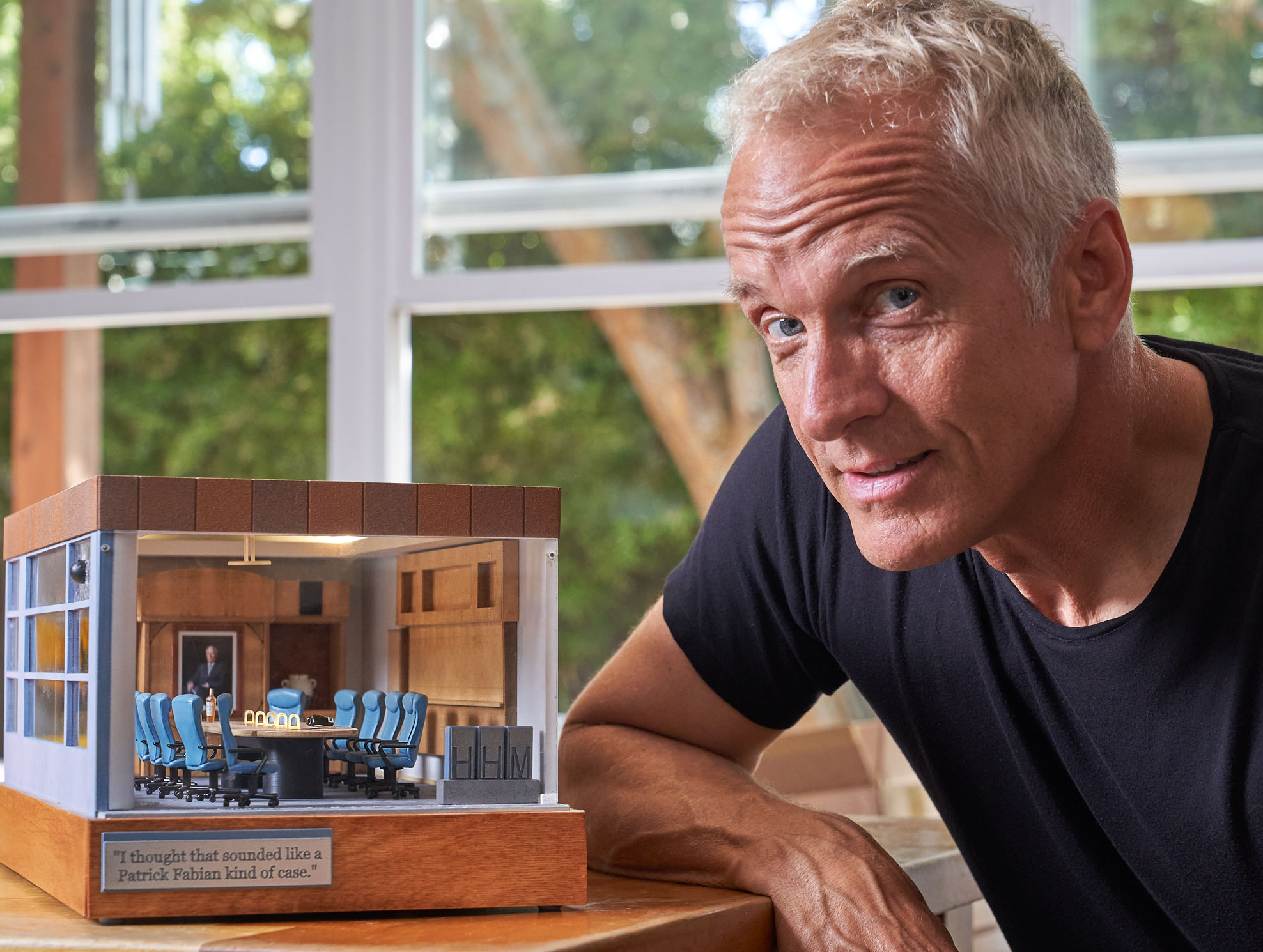Patrick Fabian poses with a model set of the conference room from Better Call Saul.