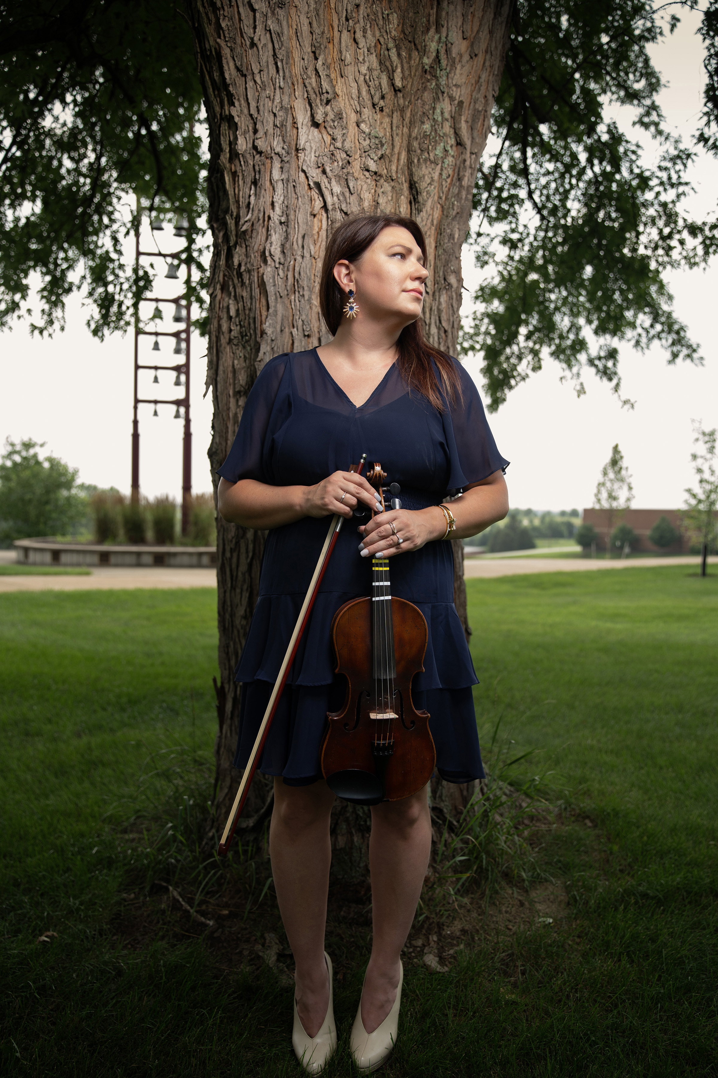Bequie Perry posting with violin in front of a tree photo by Cardoni