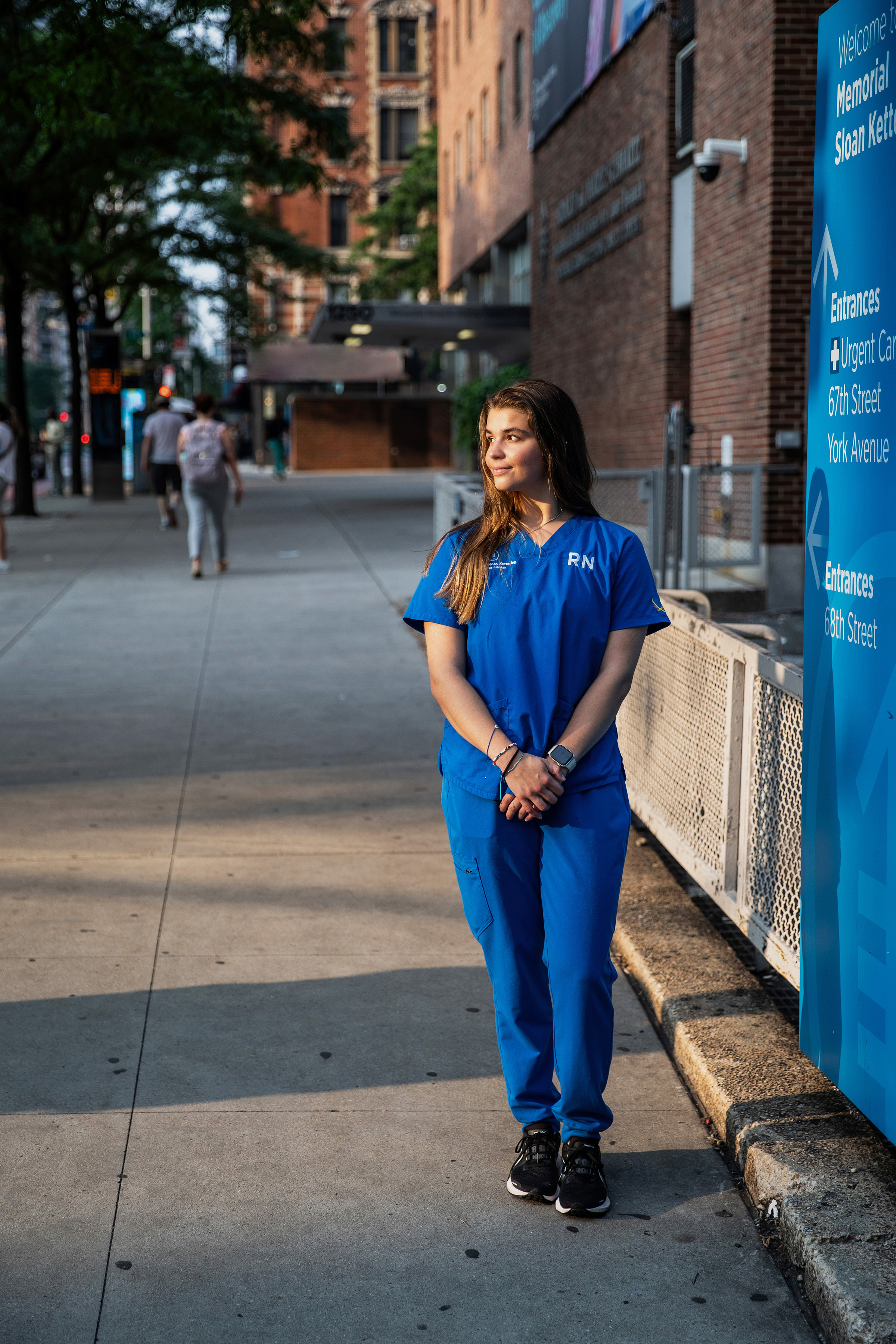 Jackie Izzo in nursing uniform walking down a sidewalk, photo by Cardoni