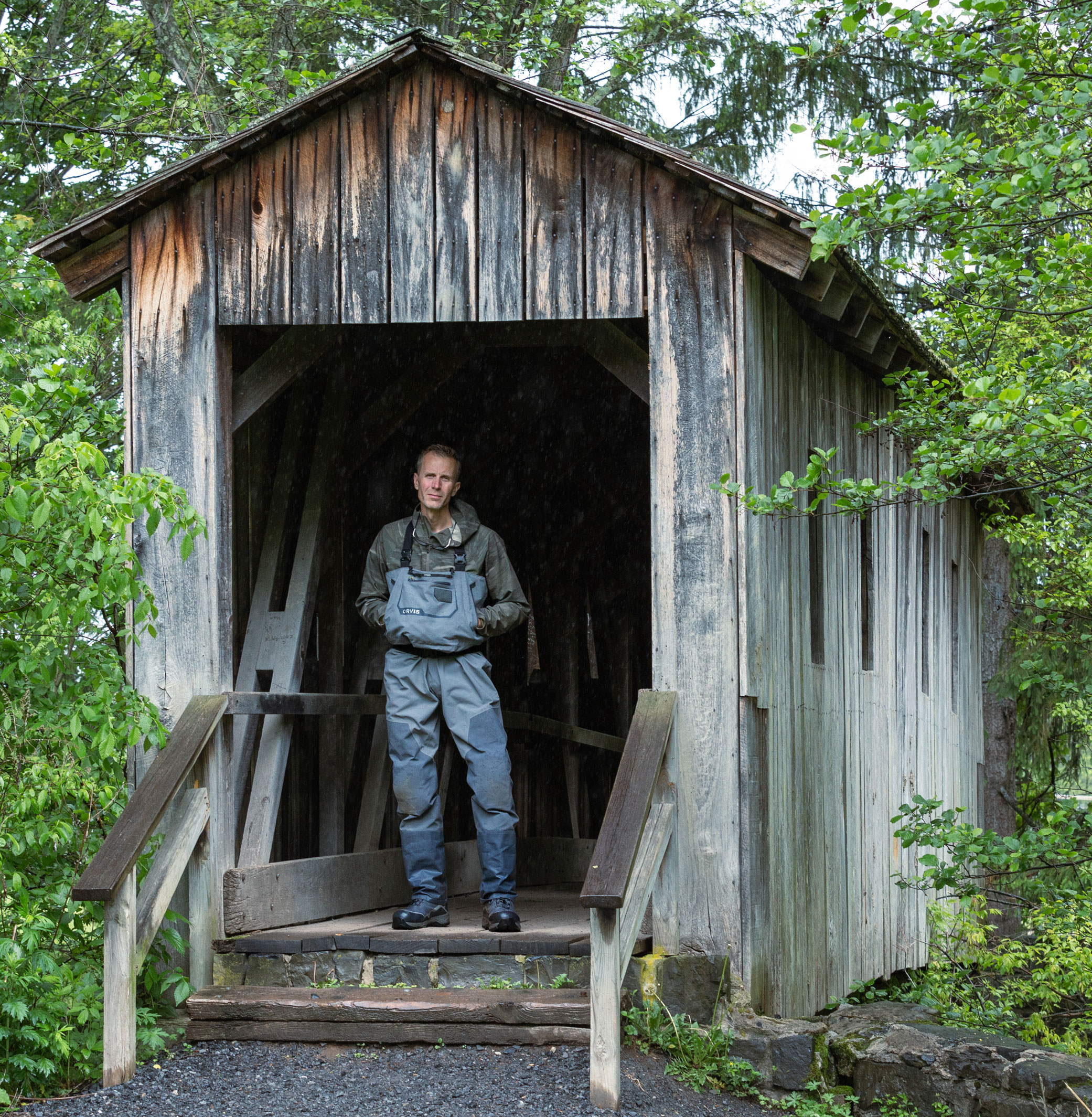 Daniels in fishing gear standing at entrance to wooden shed, photo by Nick Sloff '92 A&A