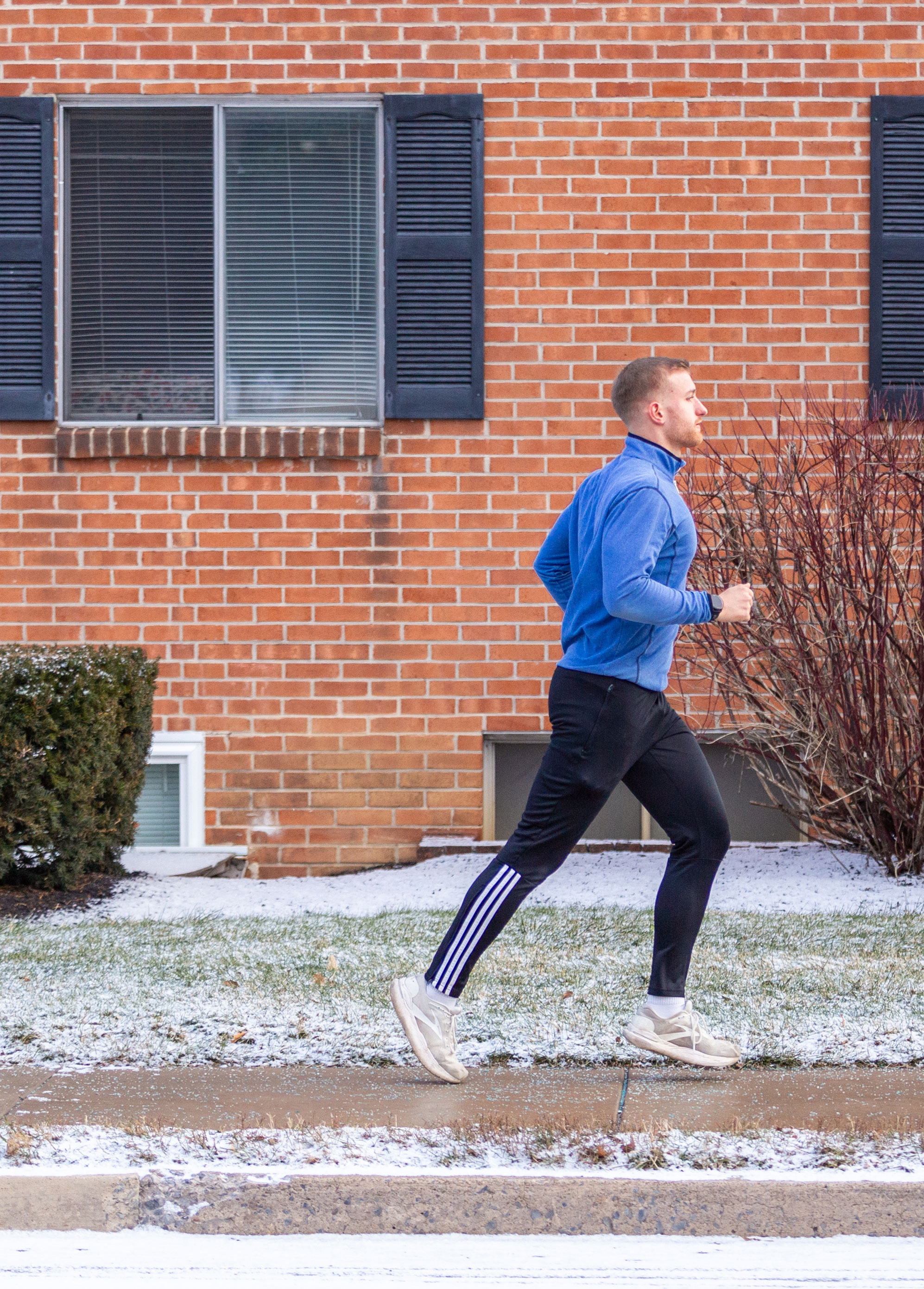 photo of Hollingham running beside a brick building by Nick Sloff '92 A&A