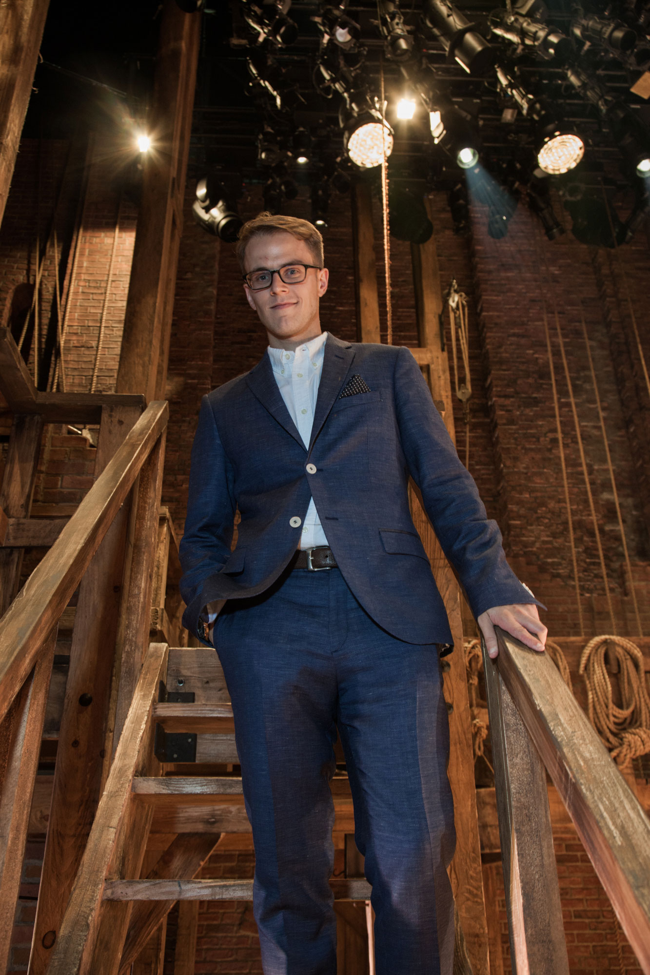 Michael Karns on wooden steps under stage lights, photo by Michael Lavine