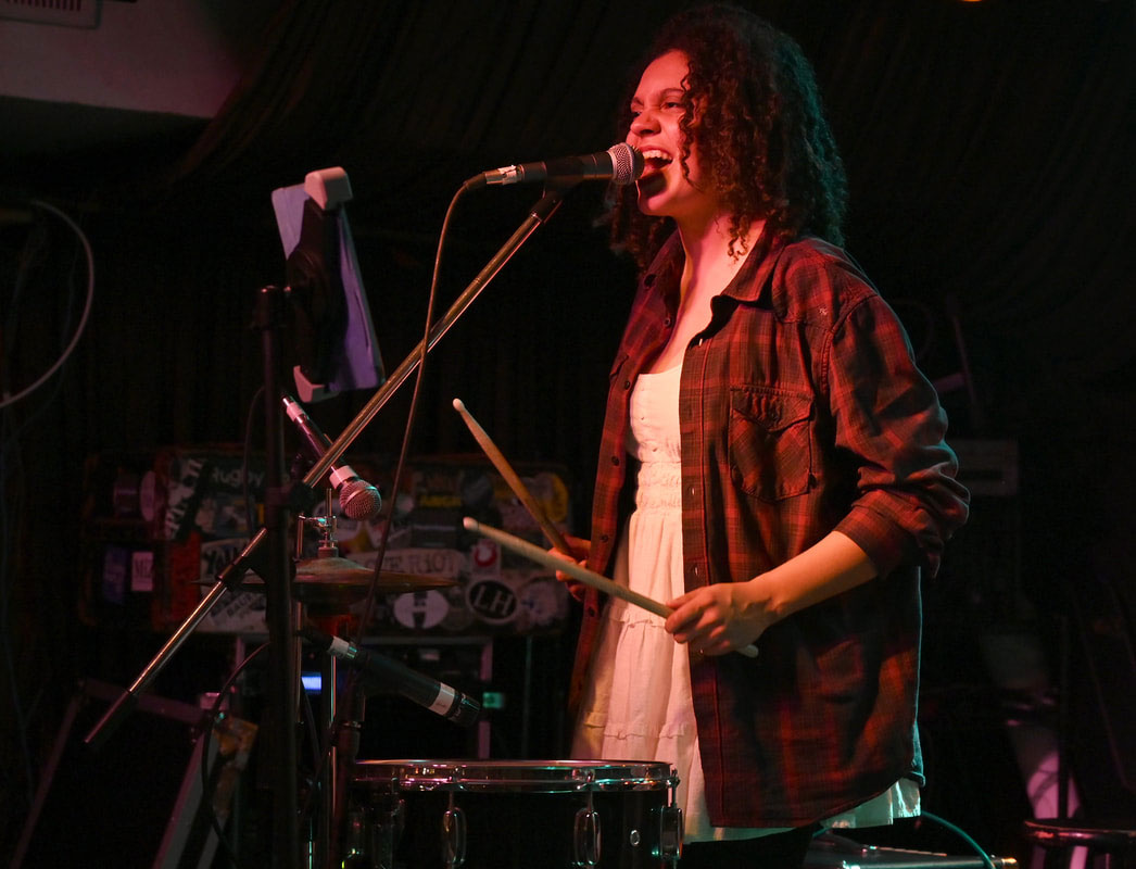 Leverenz playing drums on stage, courtesy