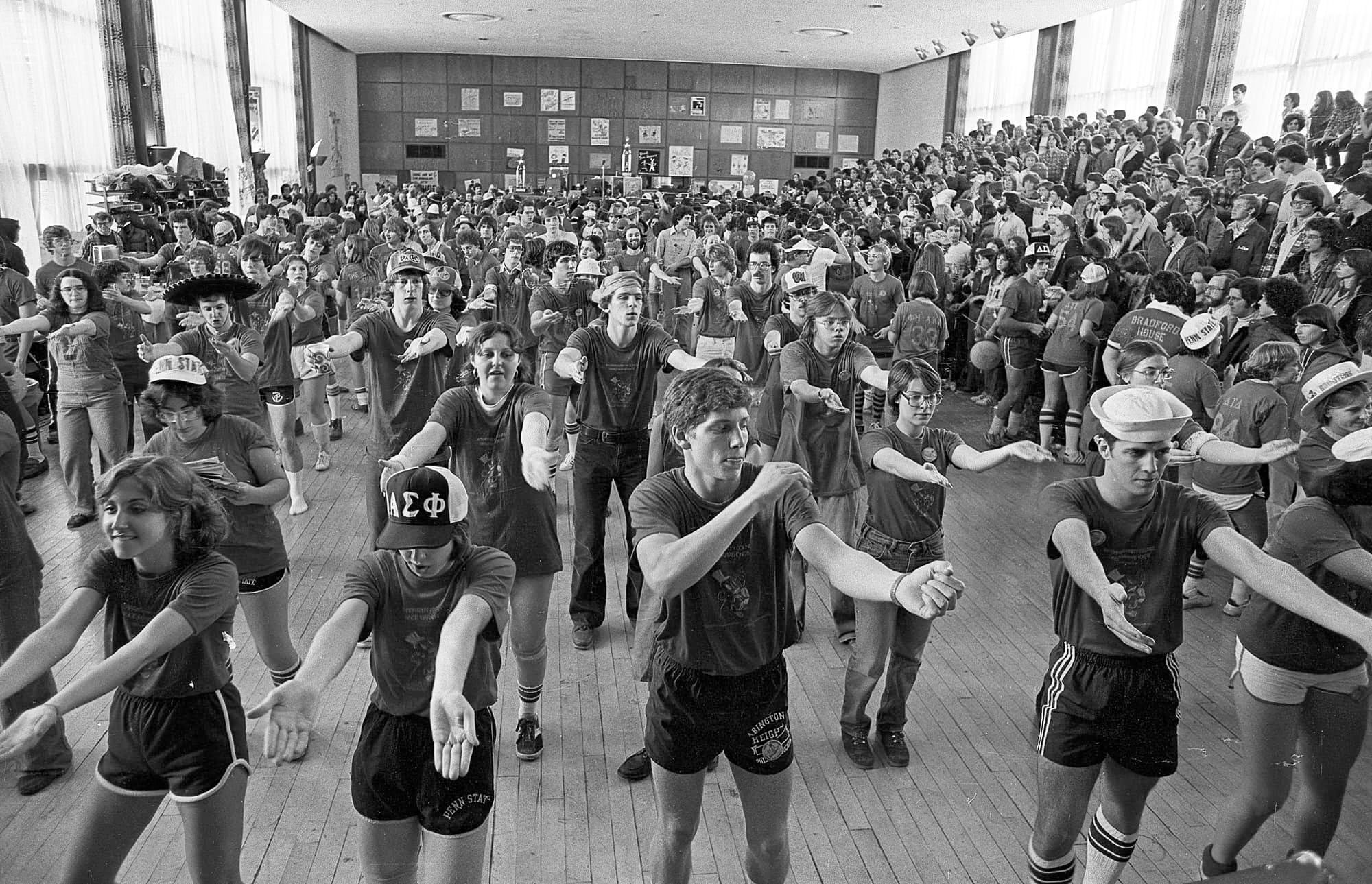 black and white photo of a large group of people doing a choreographed dance in the HUB ballroom by Pat Little