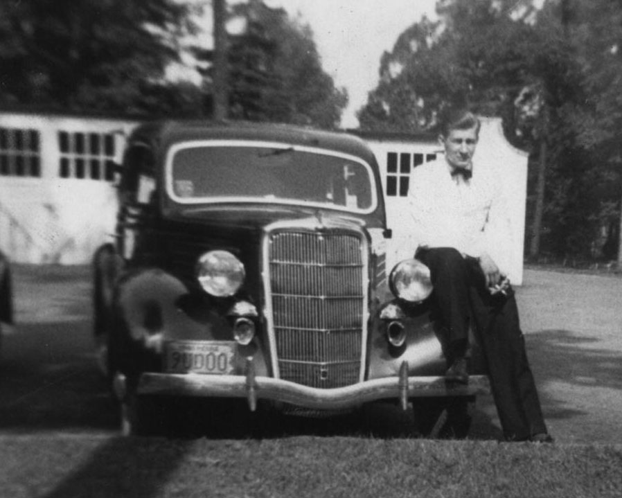 black and white photo of alum's father leaning against car on a smoke break during shift at NLI, courtesy