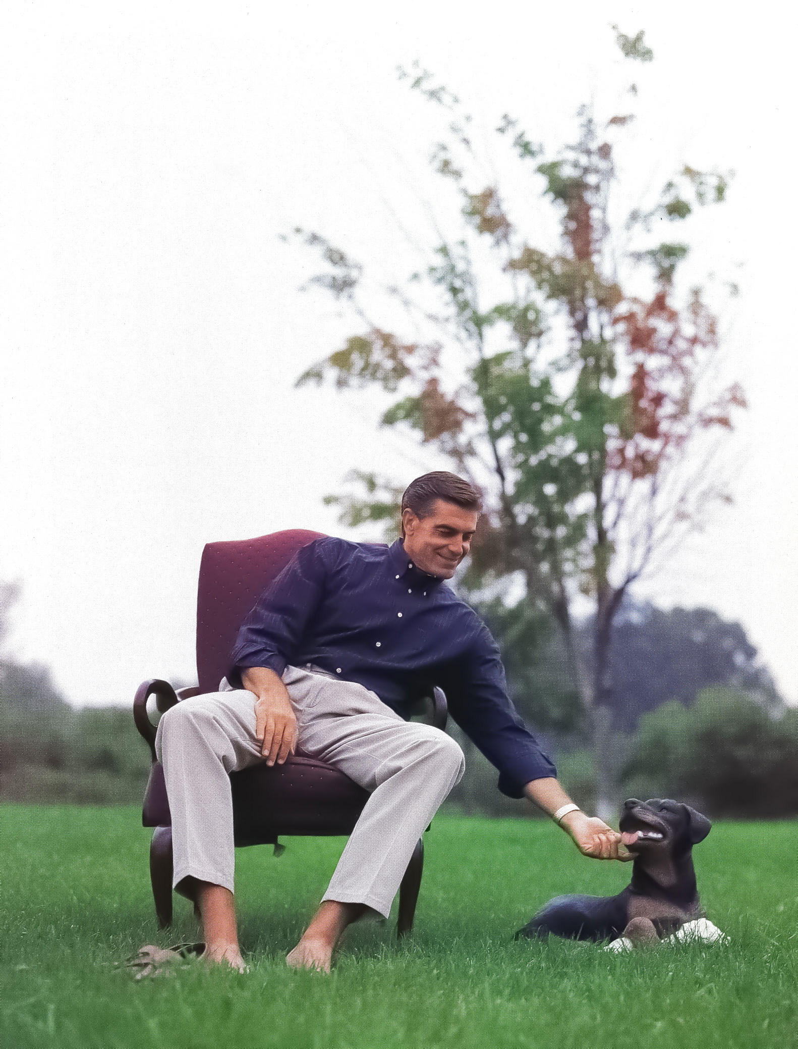 Parkhill seated outside on a bench with his dog, photo by Dan Oleski '87 A&A