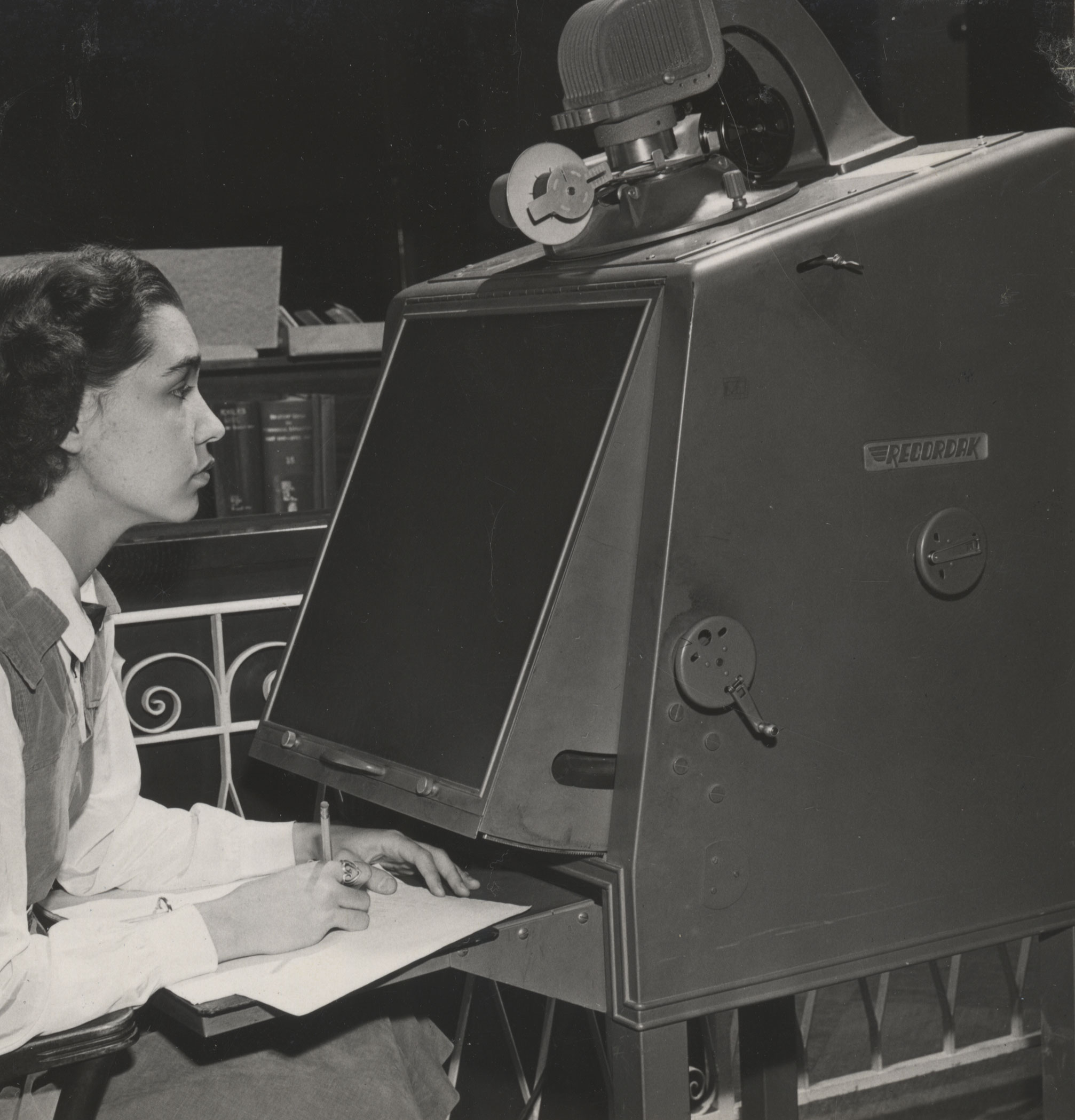 black and white photo of a student using a microfilm machine by Penn State Libraries
