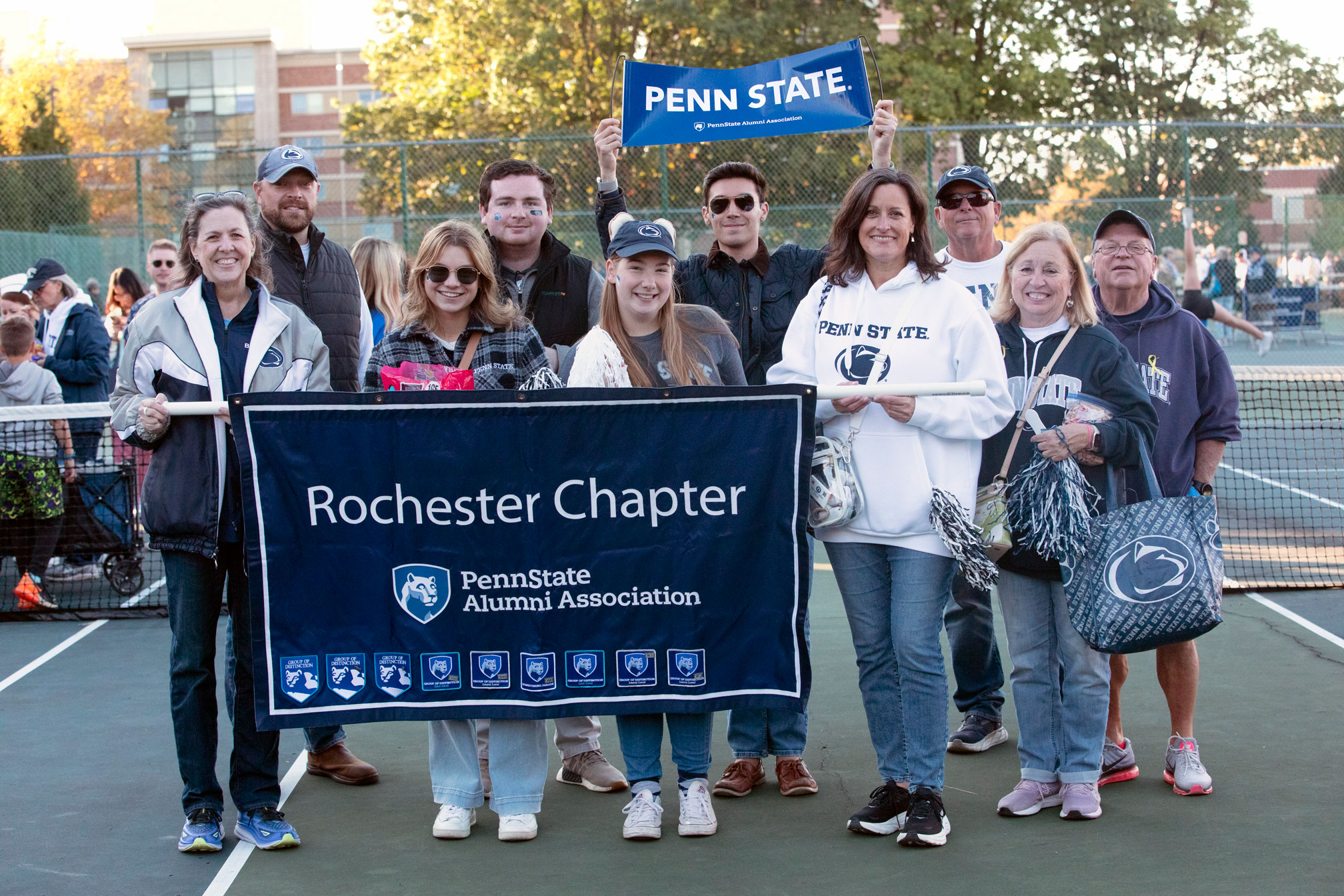 photo of Rochester chapter members outside holding their banner by Penn State Alumni Association