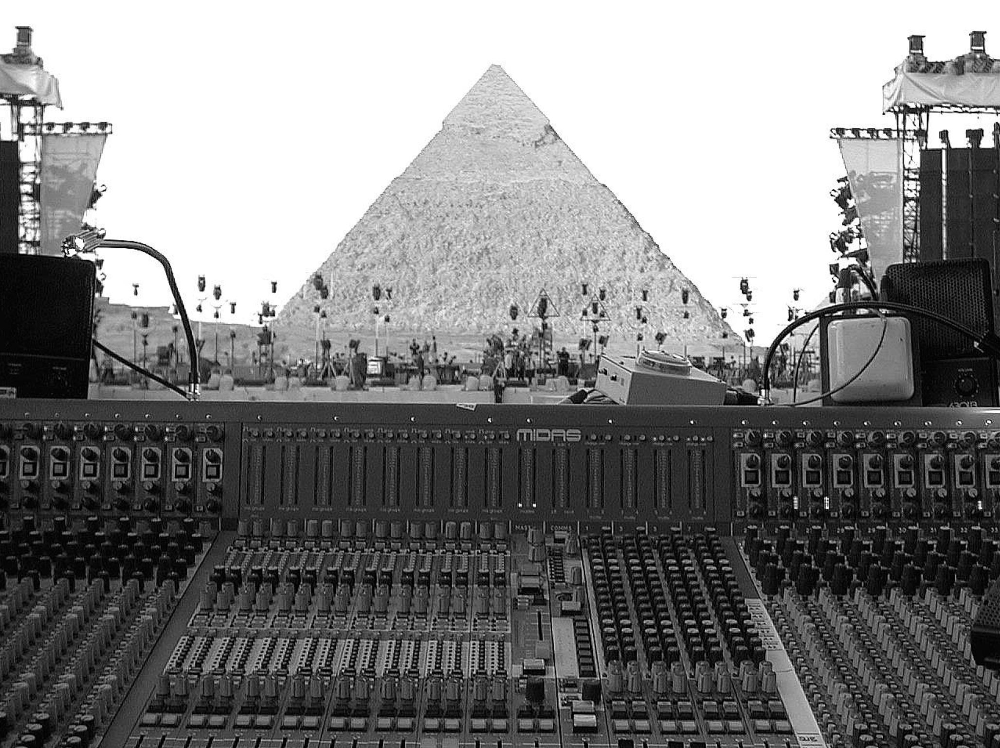 black and white photo of soundboard with Egyptian pyramid from a Jean-Michel Jarre show in background, courtesy Clair Global