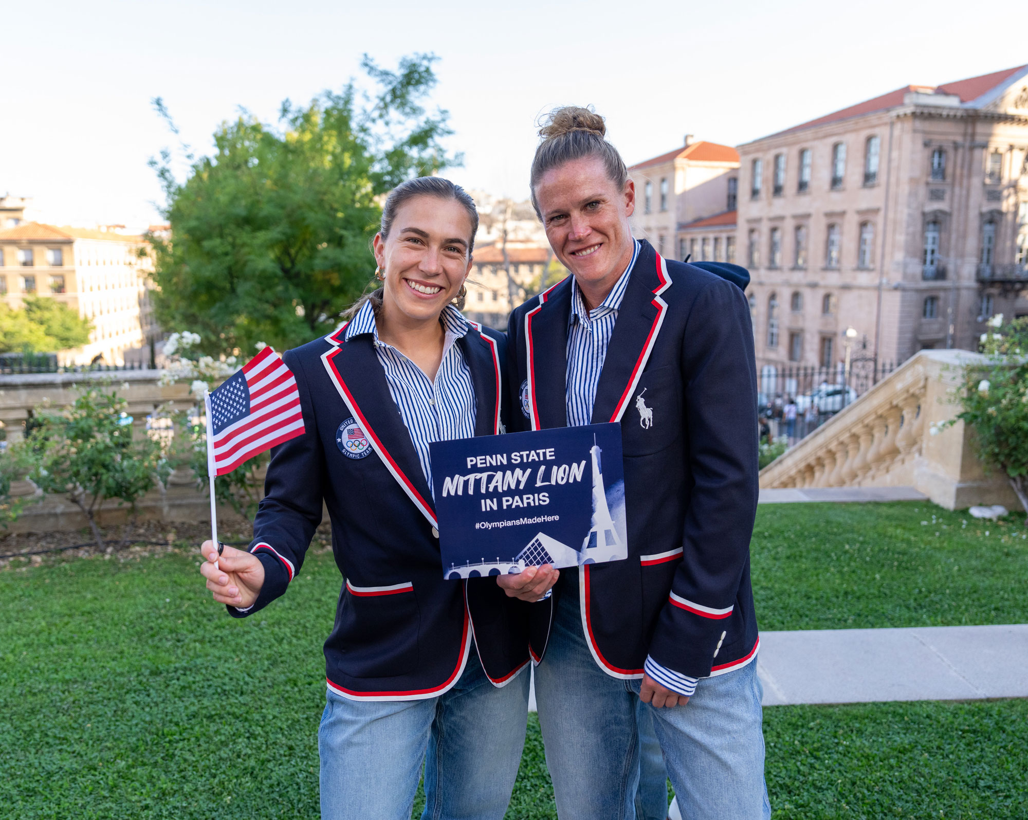 Coffey and Naeher wearing Olympics blazers and holding up an American flag and a sign that reads Penn State Nittany Lion in Paris, photo by Brad Smith/ISI/Getty Images