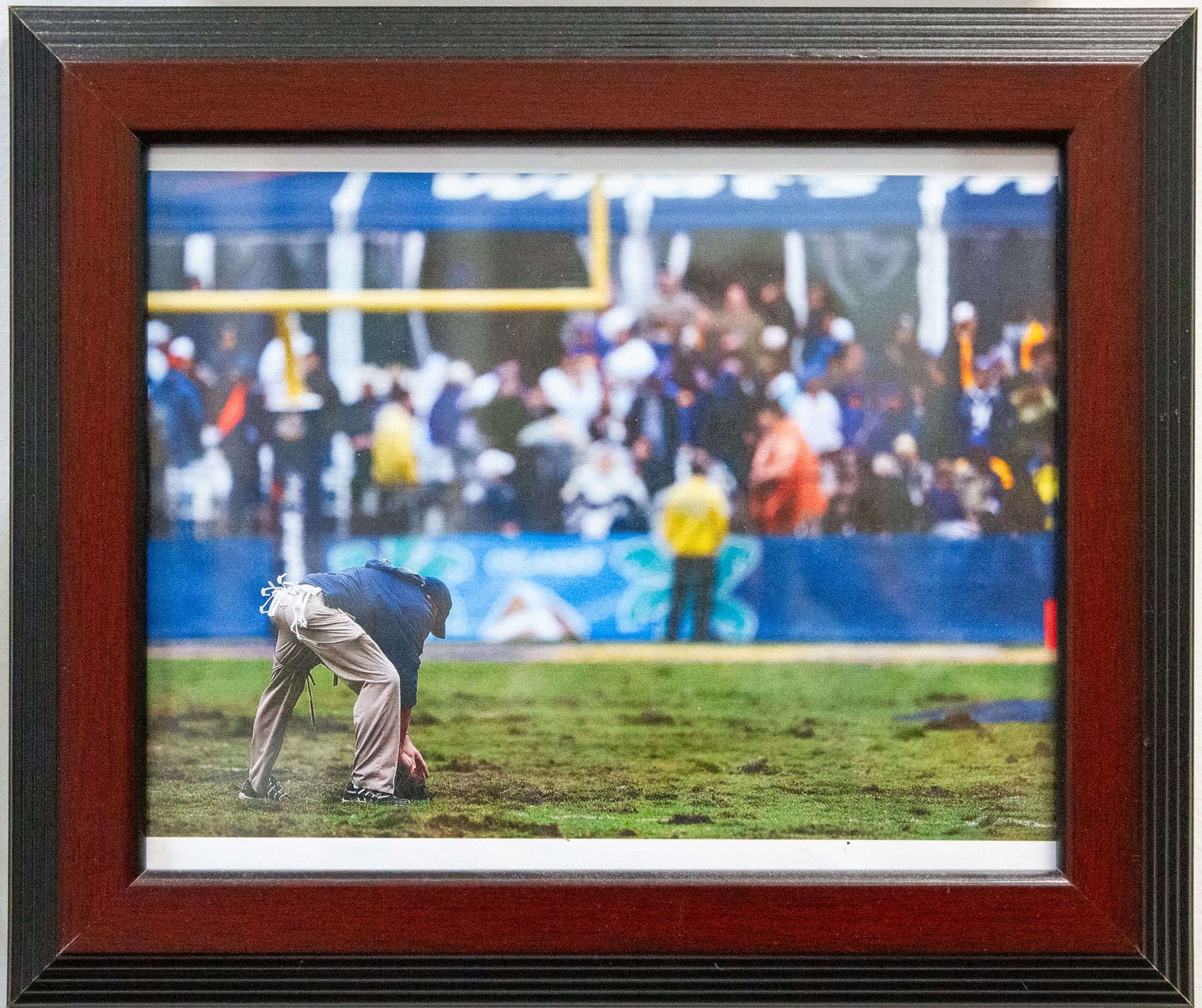 photo of a framed picture of Caldwell bending to tend to turf, by Nick Sloff '92 A&A