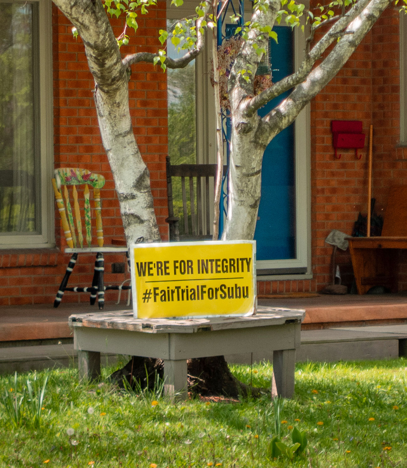 photo of a lawn sign that reads We're Here for Integrity Fair Trial for Subu, photo by Nick Sloff '92 A&A