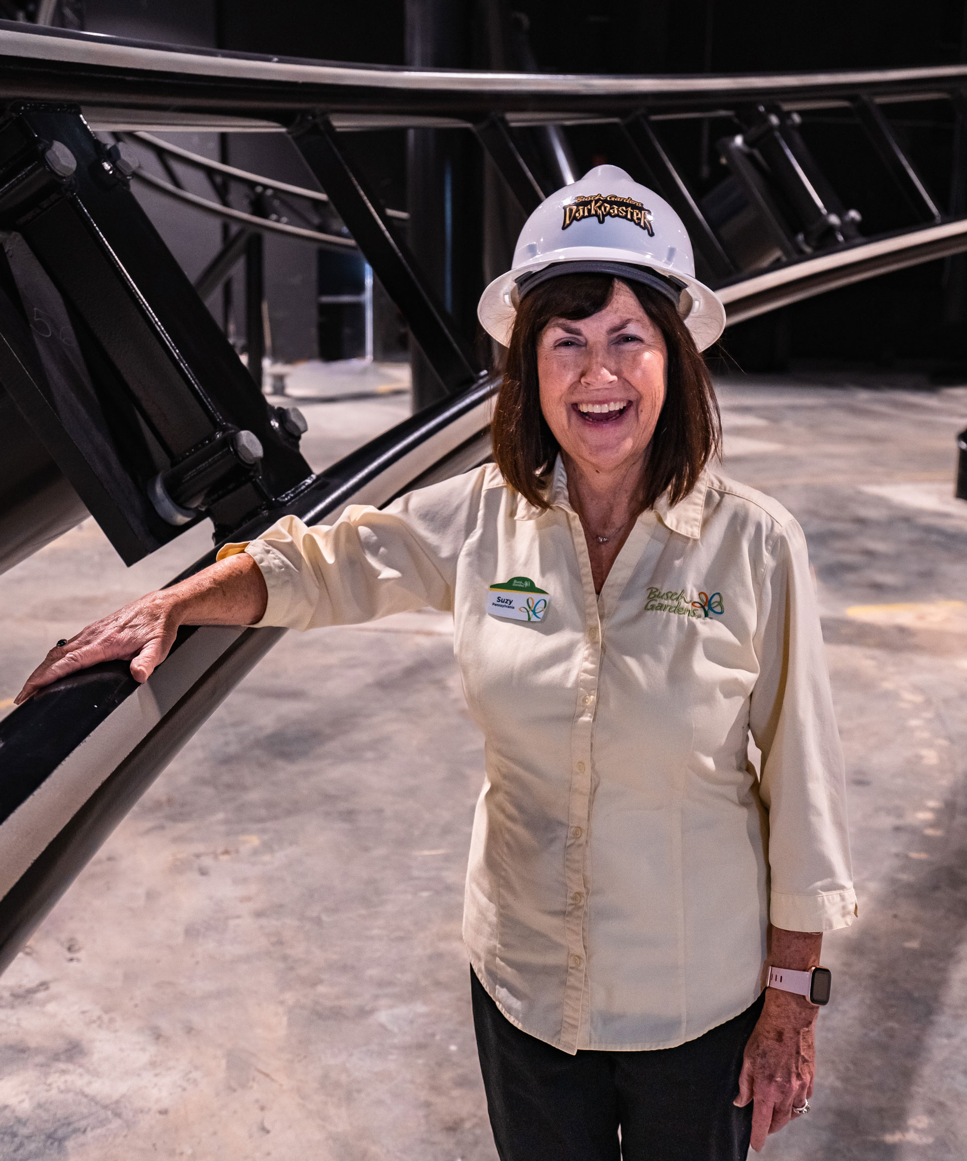 Suzy Cheely wearing hard hat posing next to roller coast track, courtesy