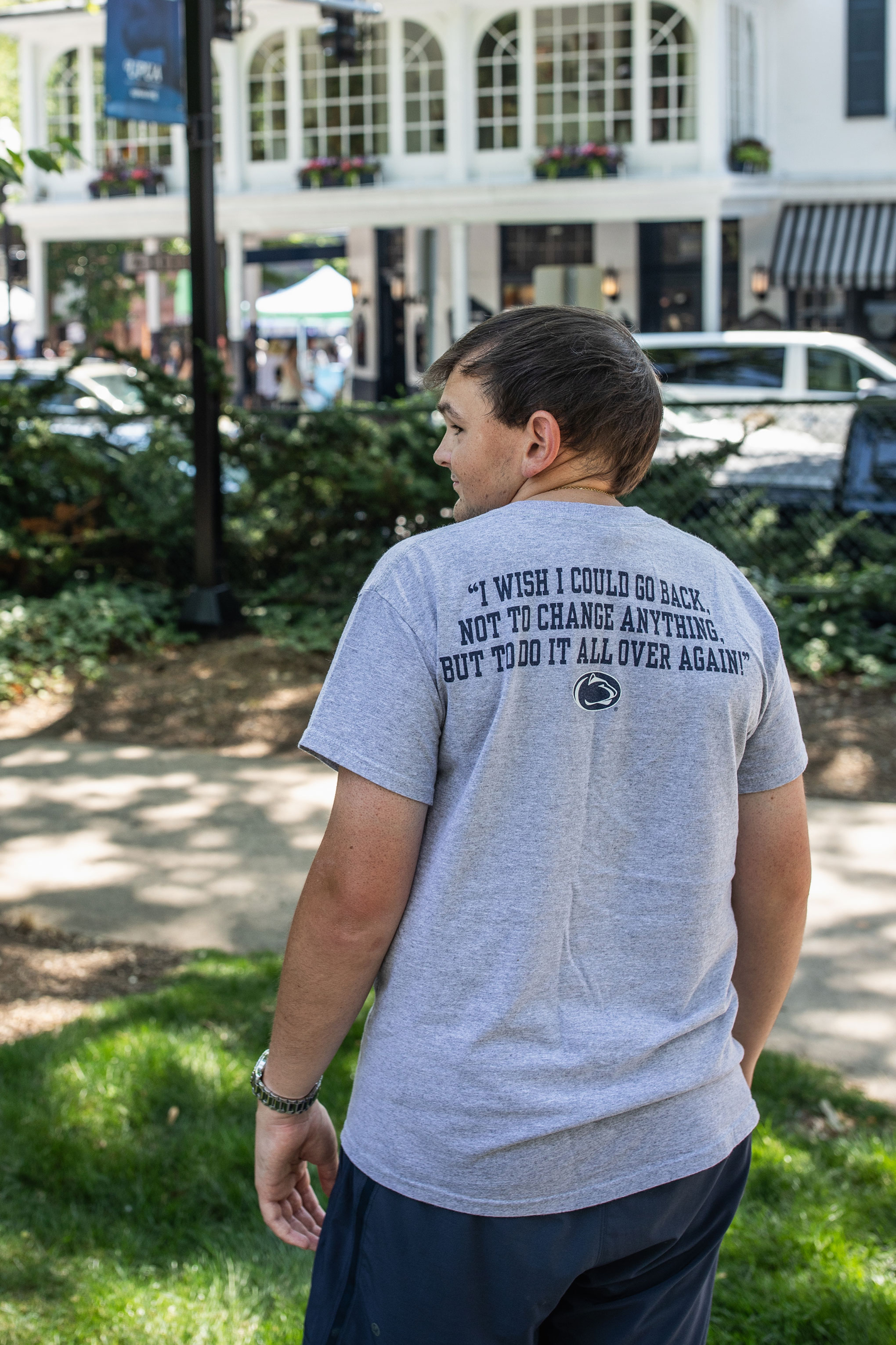 Tucker Haas with back to camera and the back of his PSU t-shirt reads "I wish I could go back. Not to change anything, but to do it all over again." Photo by Cardoni