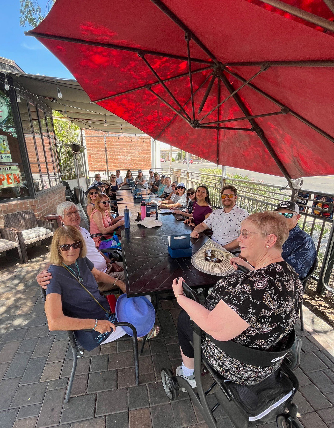 Tuscon Chapter event attendees under large red umbrella, courtesy