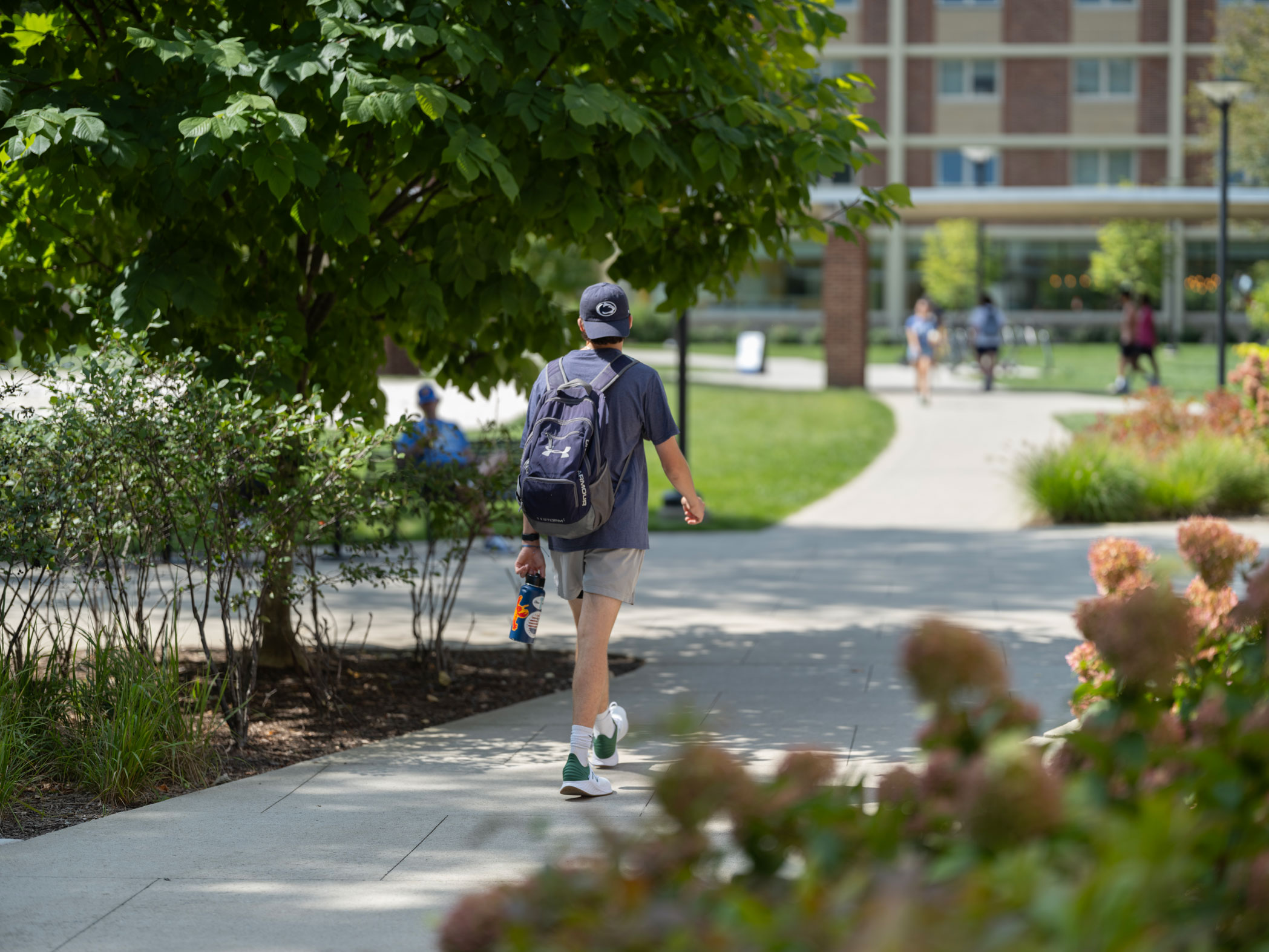 photo of a student walking at University Park during summer by Michael Owen