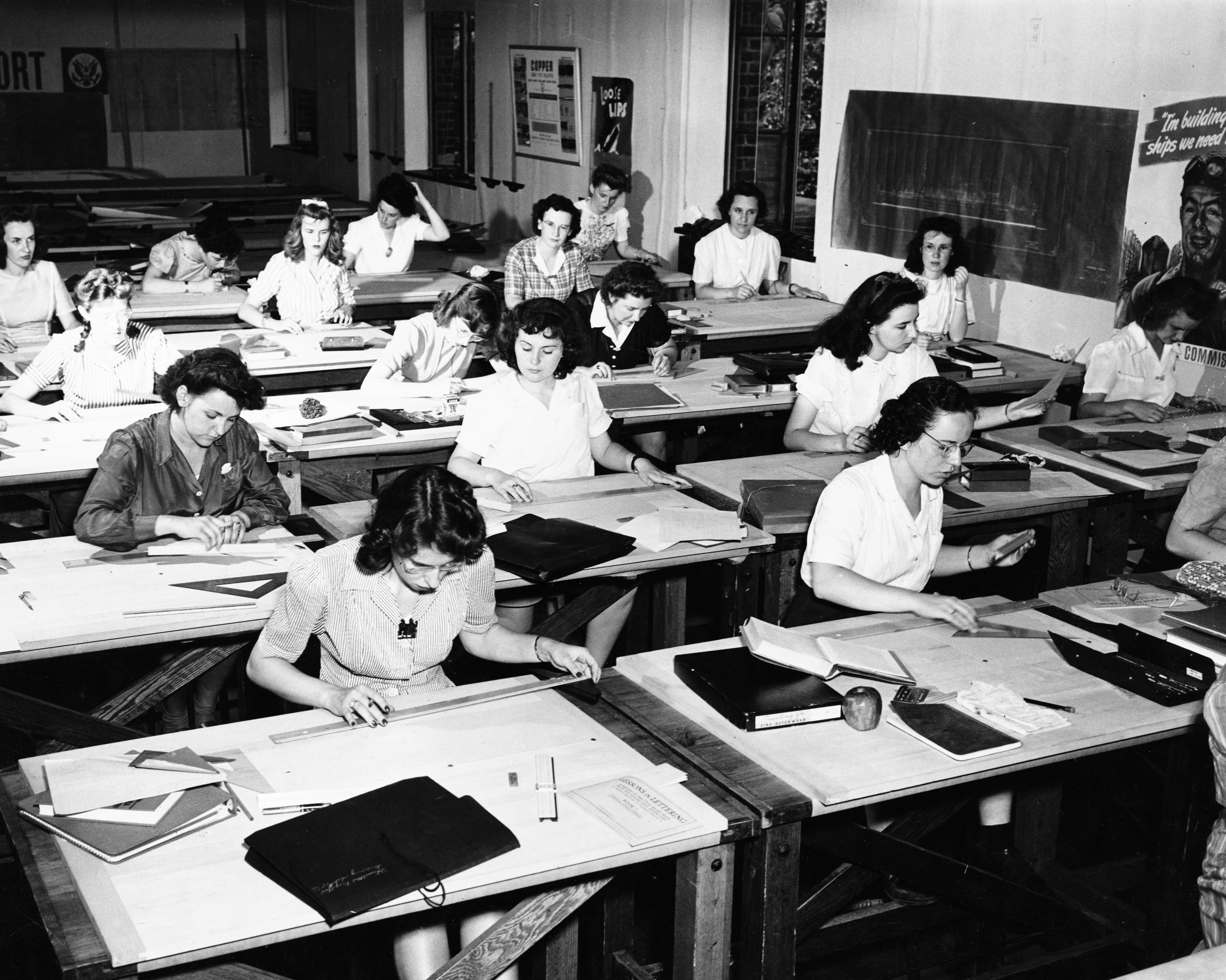 black and white photo of women in the 1950s sitting at desks in a classroom