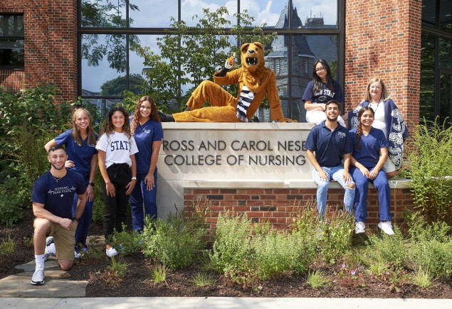 photo of students and Nittany Lion posing in front of the Ross and Carol Nese College of Nursing sign