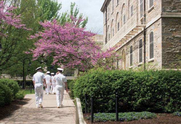 men in Navy uniforms walking on campus in spring time photo by Corinne Furjanic