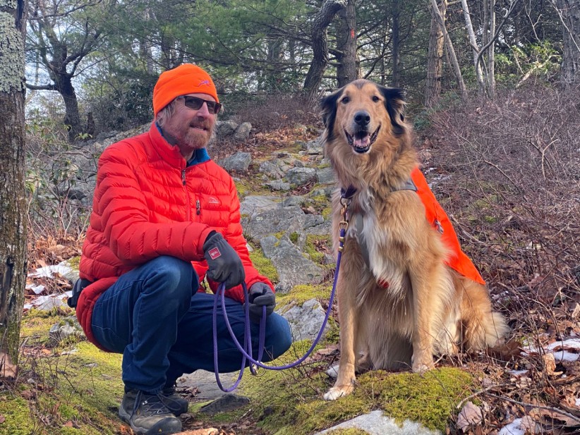 Mike Hermann pictured with his dog in the woods, courtesy Hermann