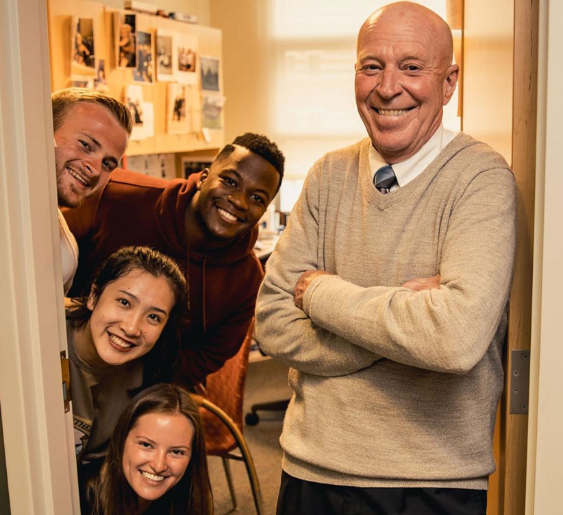 Novack and four students smiling in doorway photo by Cardoni