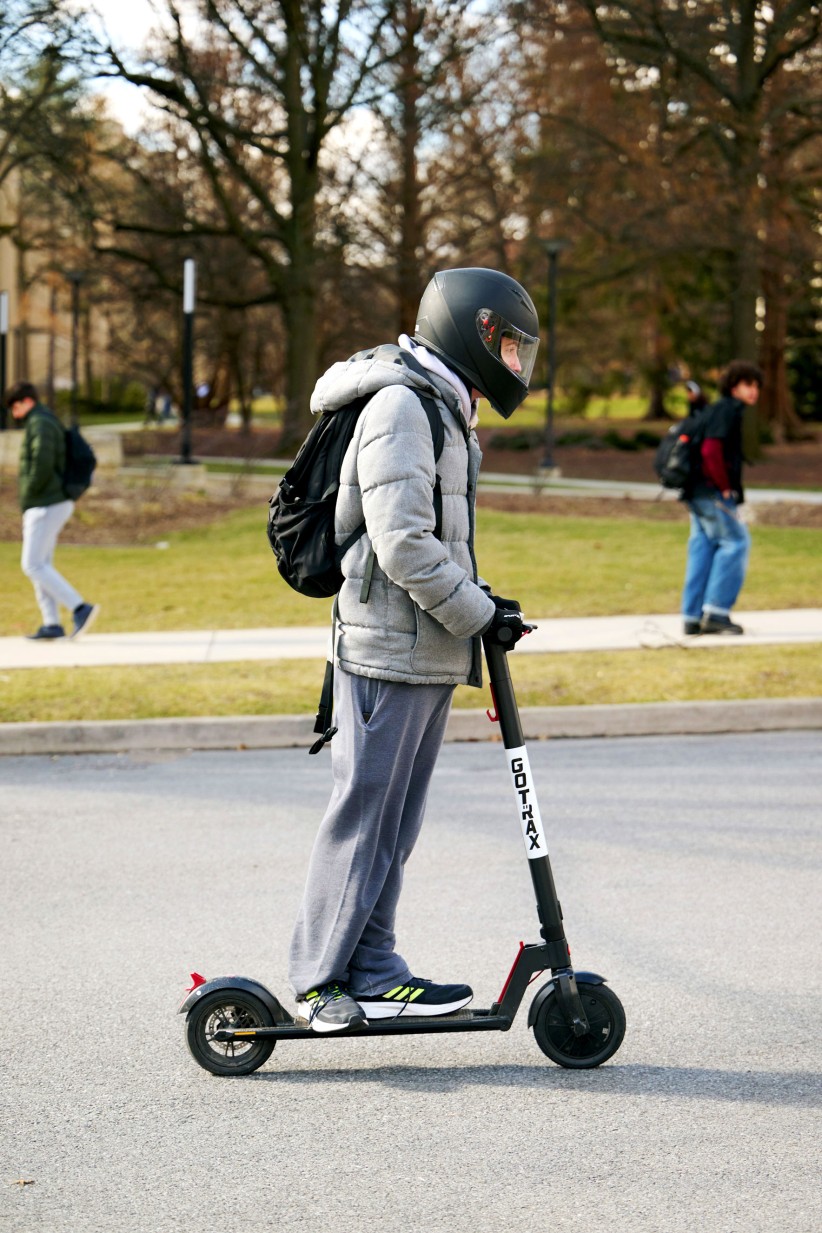 a helmeted student riding an electric scooter, photo by Steve Tressler