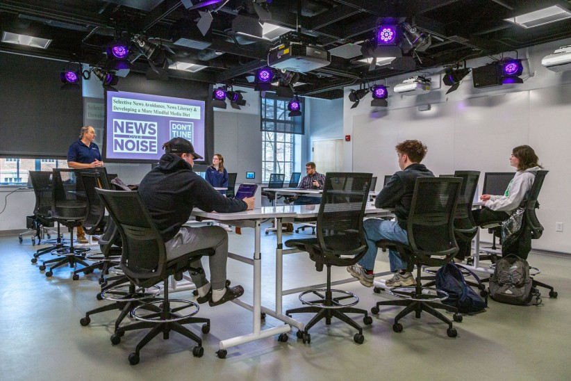 News Literacy Ambassadors sitting around a table during production of a News Over Noise podcast, photo by Nick Sloff '92 A&A