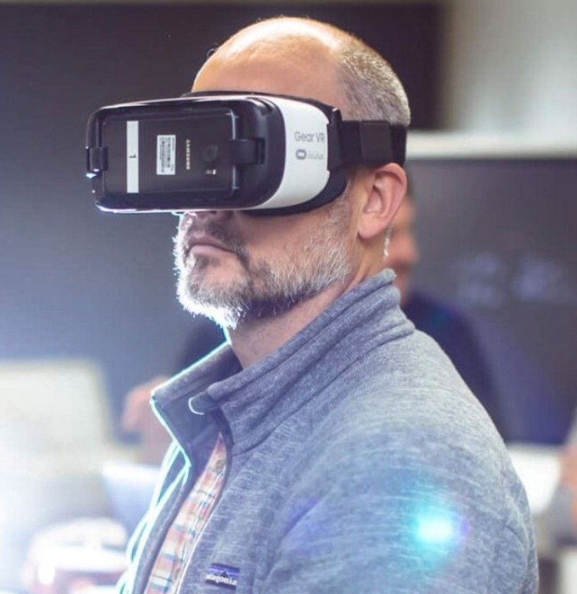 photo of a man wearing a virtual reality headset covering his eyes, photo by Center for Immersive Experiences