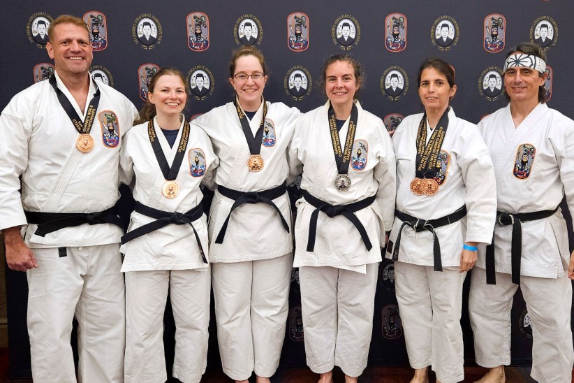 group photo of Karate Club competitors Estes, Gabel, Egan, Decker, Jennifer Koszarsky, and Jaeson Koszarsky, by Penn State Karate Club